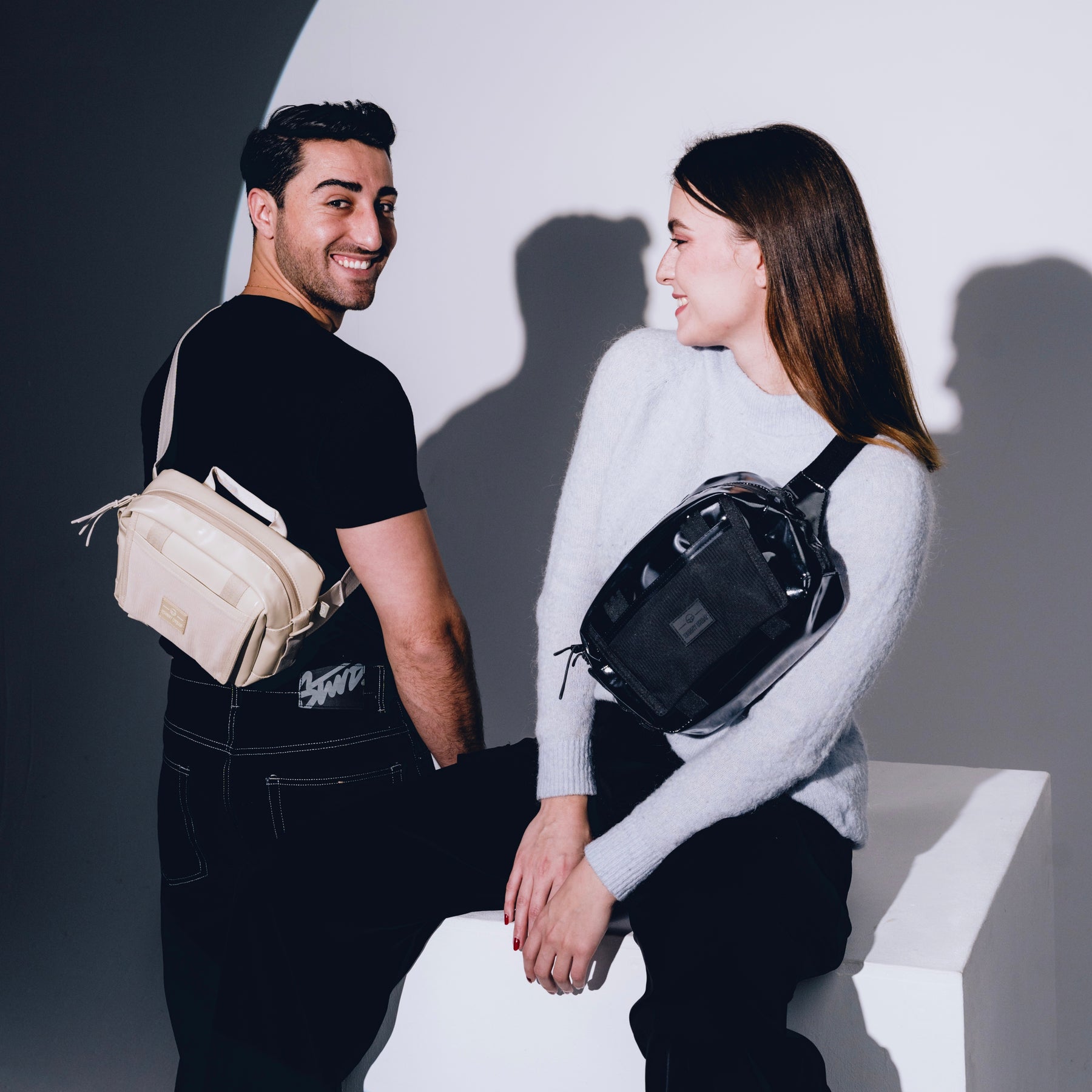 Mann mit schwarzer Umhängetasche und Frau mit schwarzer Lenkertasche Fahrrad 'Nelson' lächeln sich an