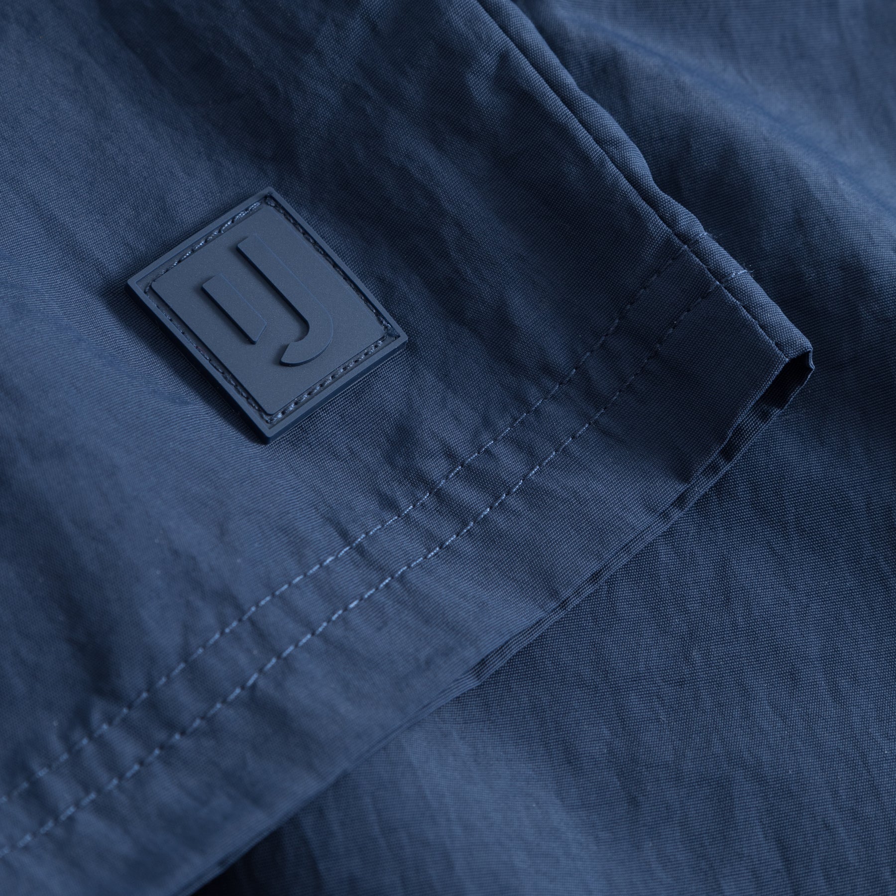 Nahaufnahme der navyblauen Badehose 'Jay' mit Johnny Urban Logo-Patch