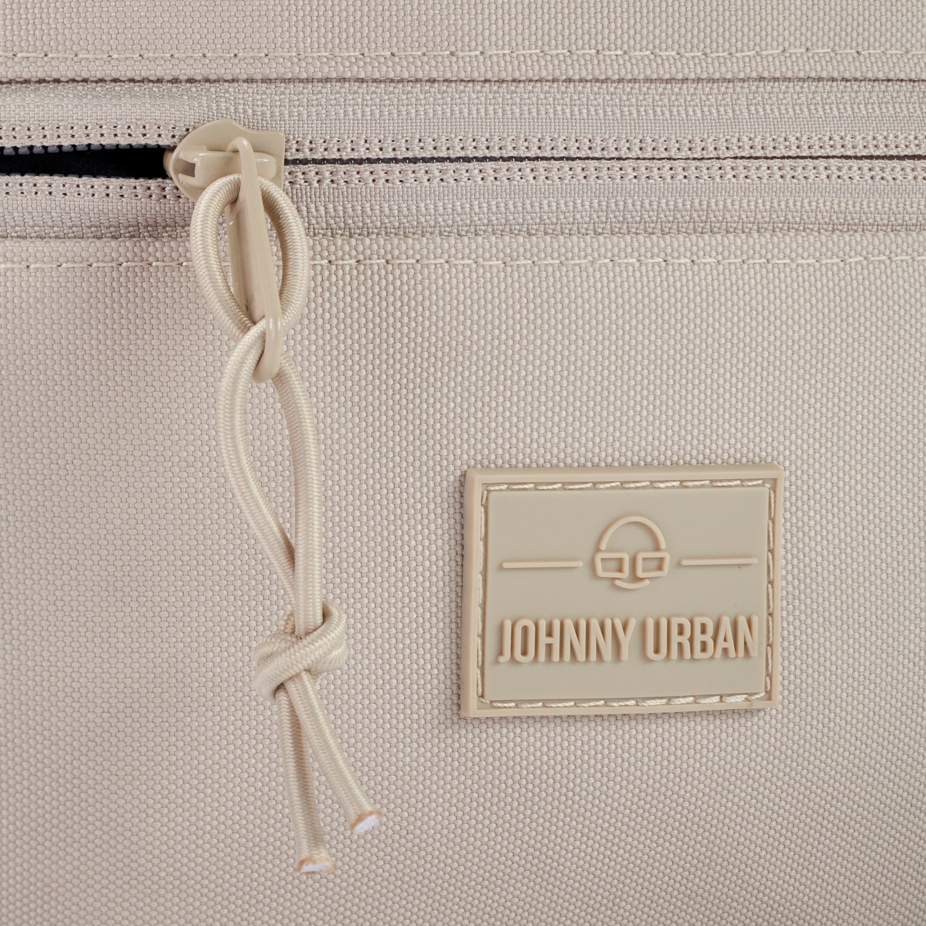 Nahaufnahme des Reißverschlusses und des Johnny Urban Logos der Bauchtasche 'Erik Large' in Sandbeige