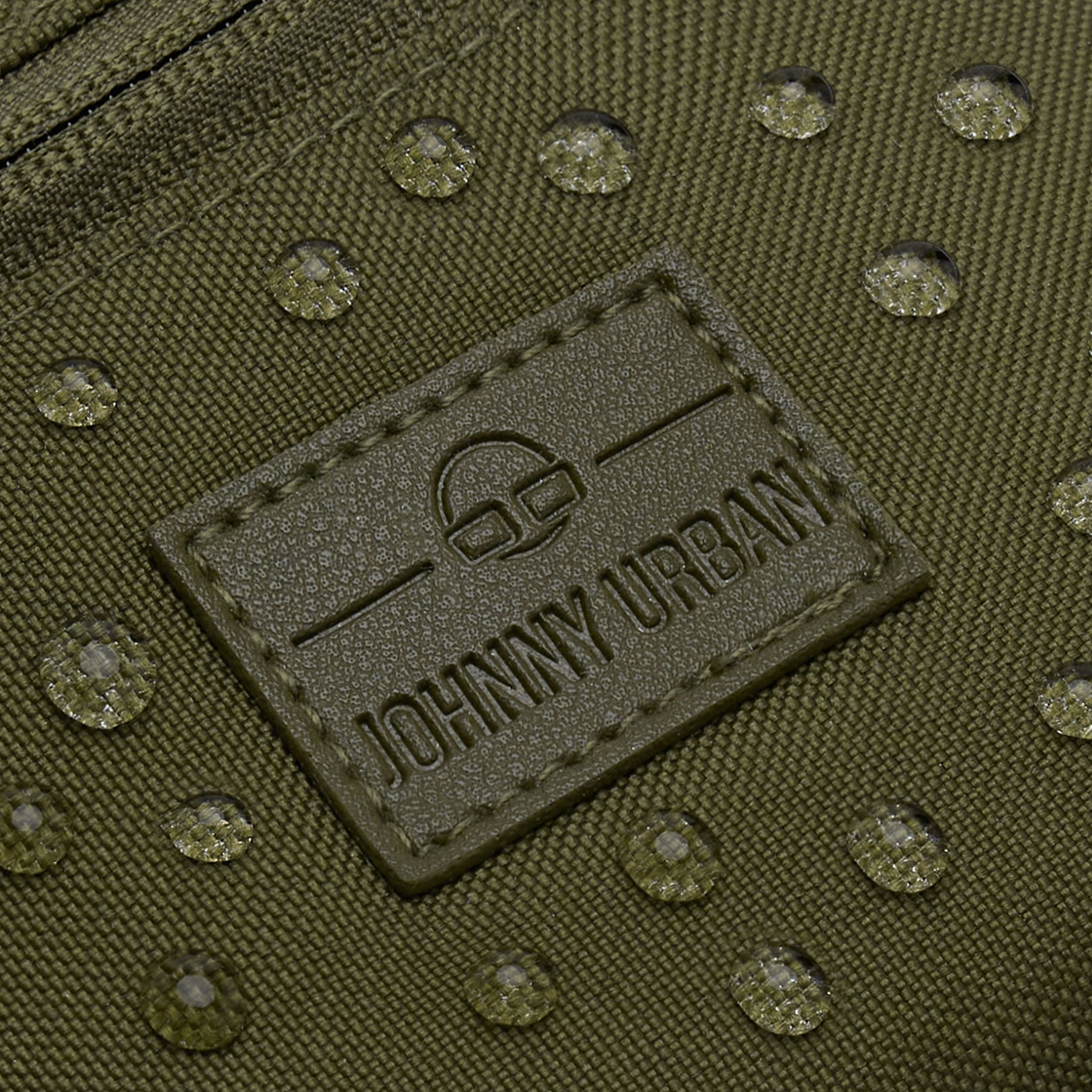 Nahaufnahme der wasserabweisenden Oberfläche und des Markenlabels der olivgrünen Bauchtasche 'Erik Small' von Johnny Urban
