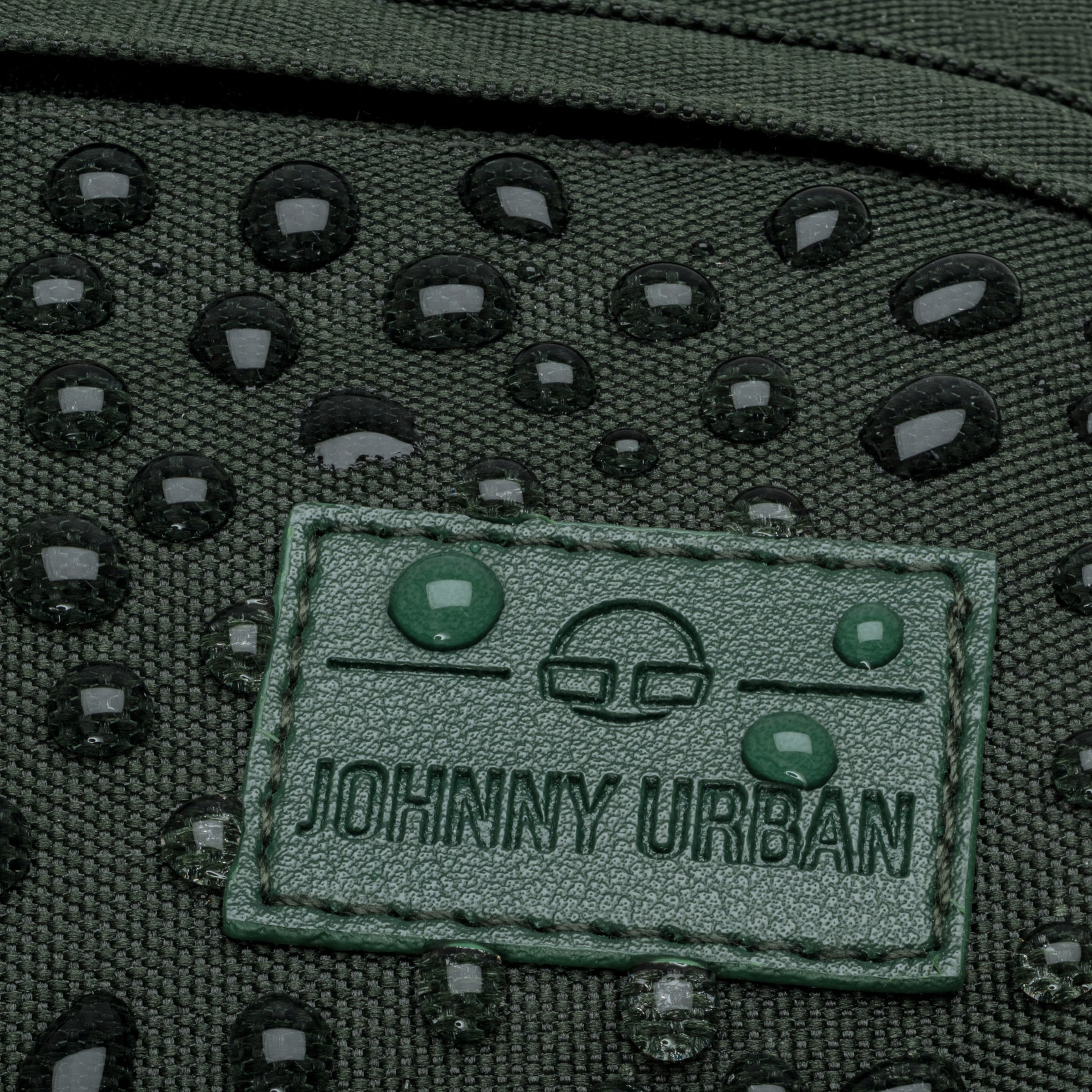 Wasserabweisende grüne Bauchtasche 'Tom' von Johnny Urban mit Wassertropfen auf dem Logo-Patch