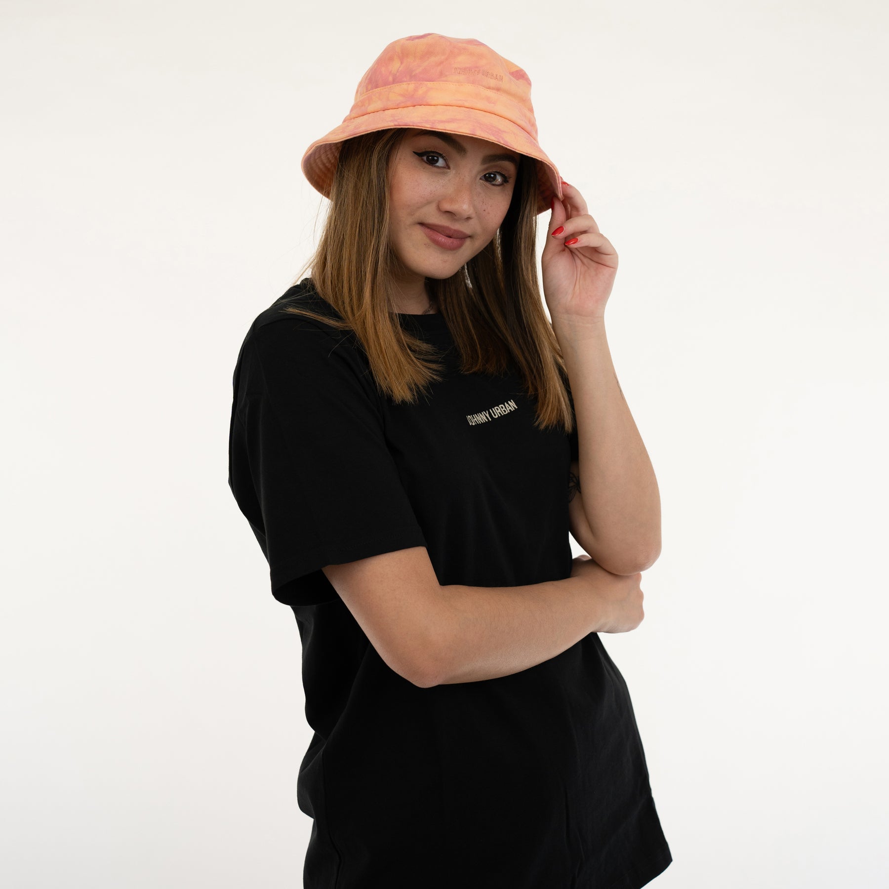 Frau trägt orangefarbenen Bucket Hat 'Gill' und schwarzes T-Shirt mit 'Johnny Urban' Schriftzug