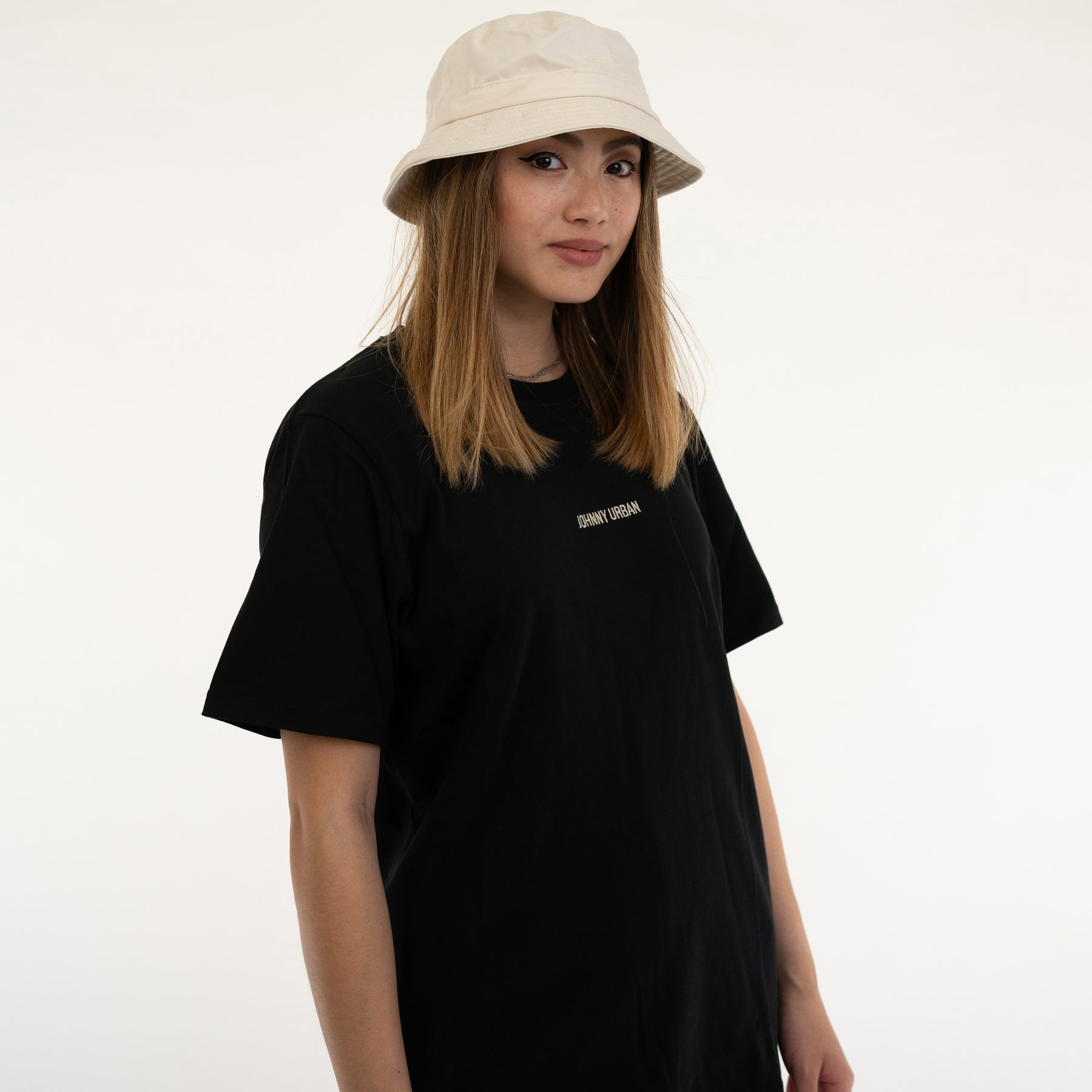 Frau trägt beige Bucket Hat 'Gill' und schwarzes T-Shirt mit 'Johnny Urban' Aufschrift