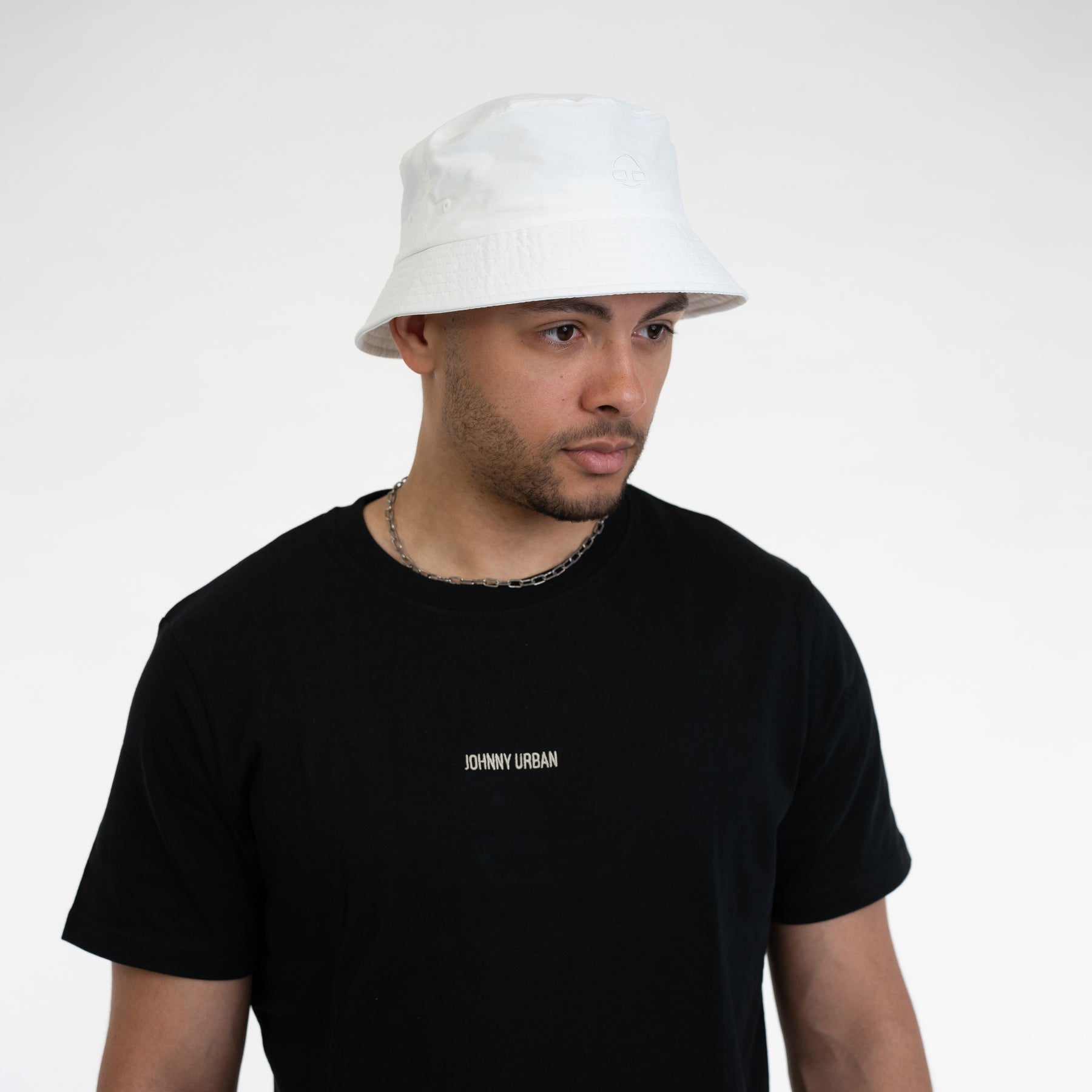 Mann trägt weißen Bucket Hat 'Bob' und schwarzes Johnny Urban T-Shirt mit Logo