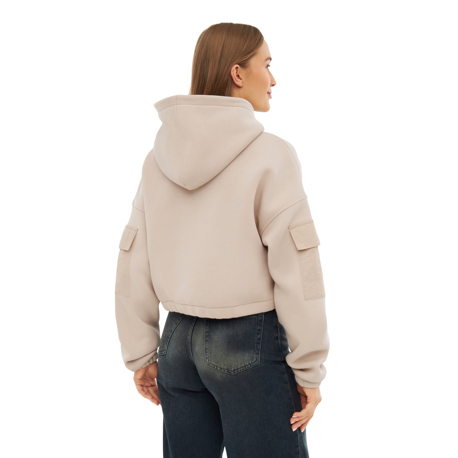 Rückansicht eines Models mit sandfarbenem, kurz geschnittenem Hoodie 'Carly' mit Kapuze und Taschen an den Ärmeln