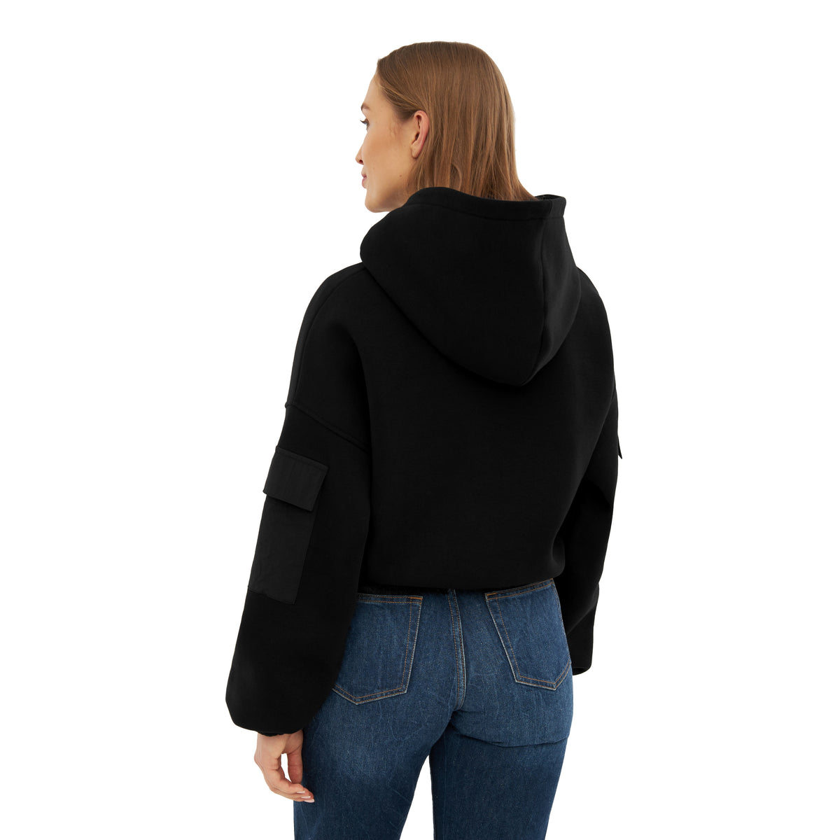 Damen trägt schwarzen Cropped Hoodie ‚Carly‘ mit Kapuze und Tasche am linken Ärmel