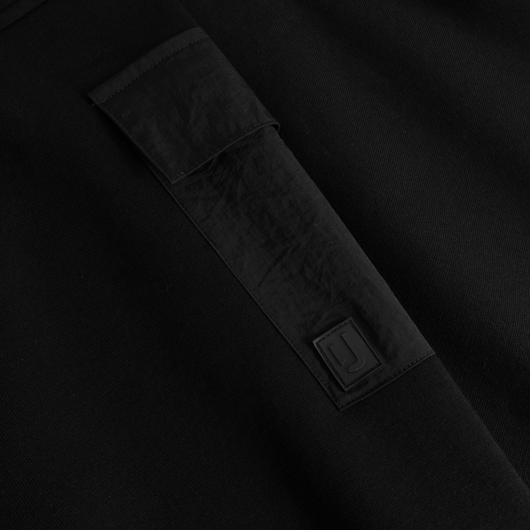 Schwarzes Ärmel-Detail mit Stoffpatch und Johnny Urban Logo auf dem Cropped Hoodie 'Carly'