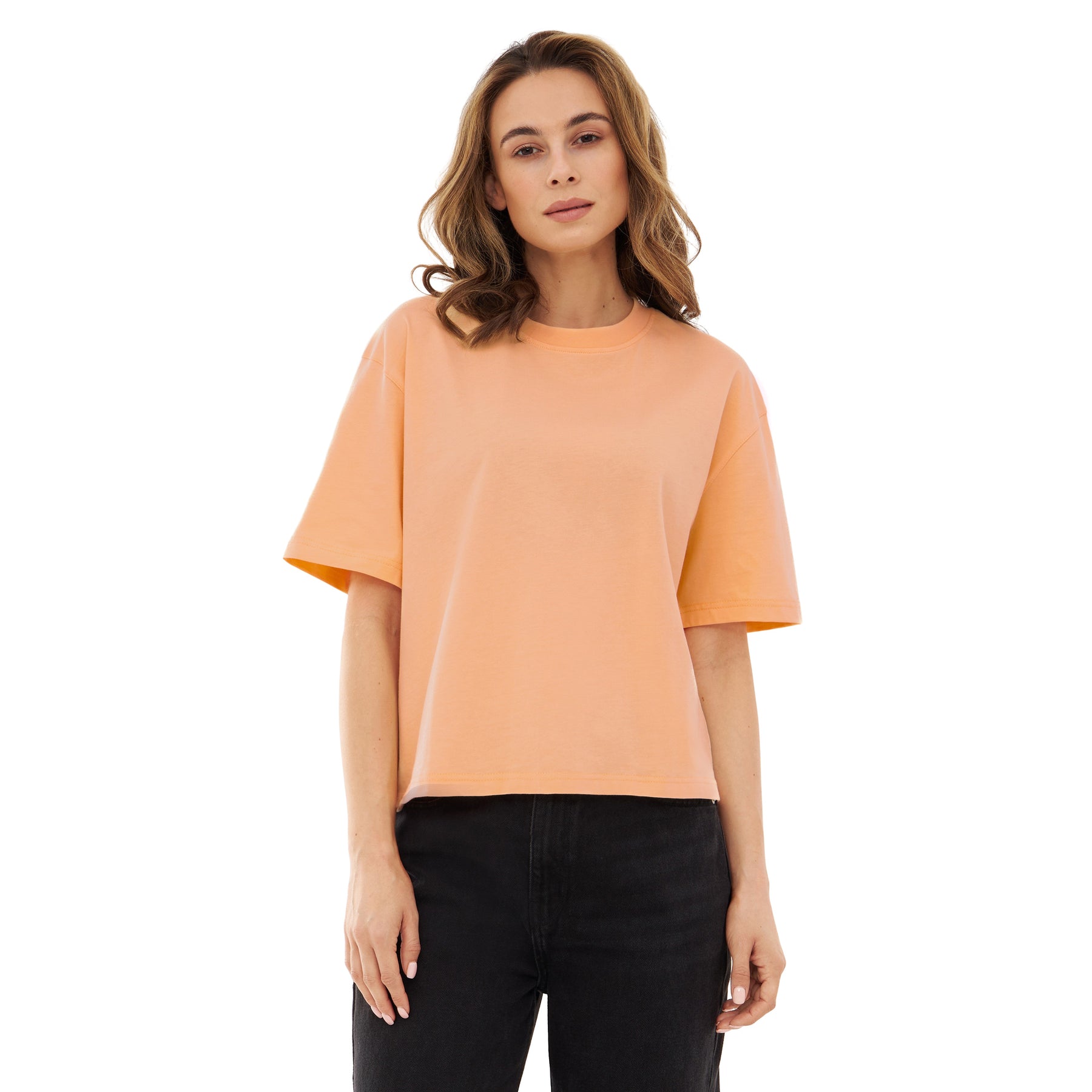 Damen trägt Cropped T-Shirt 'Zoey' in Pfirsich mit kurzen Ärmeln und Rundhalsausschnitt
