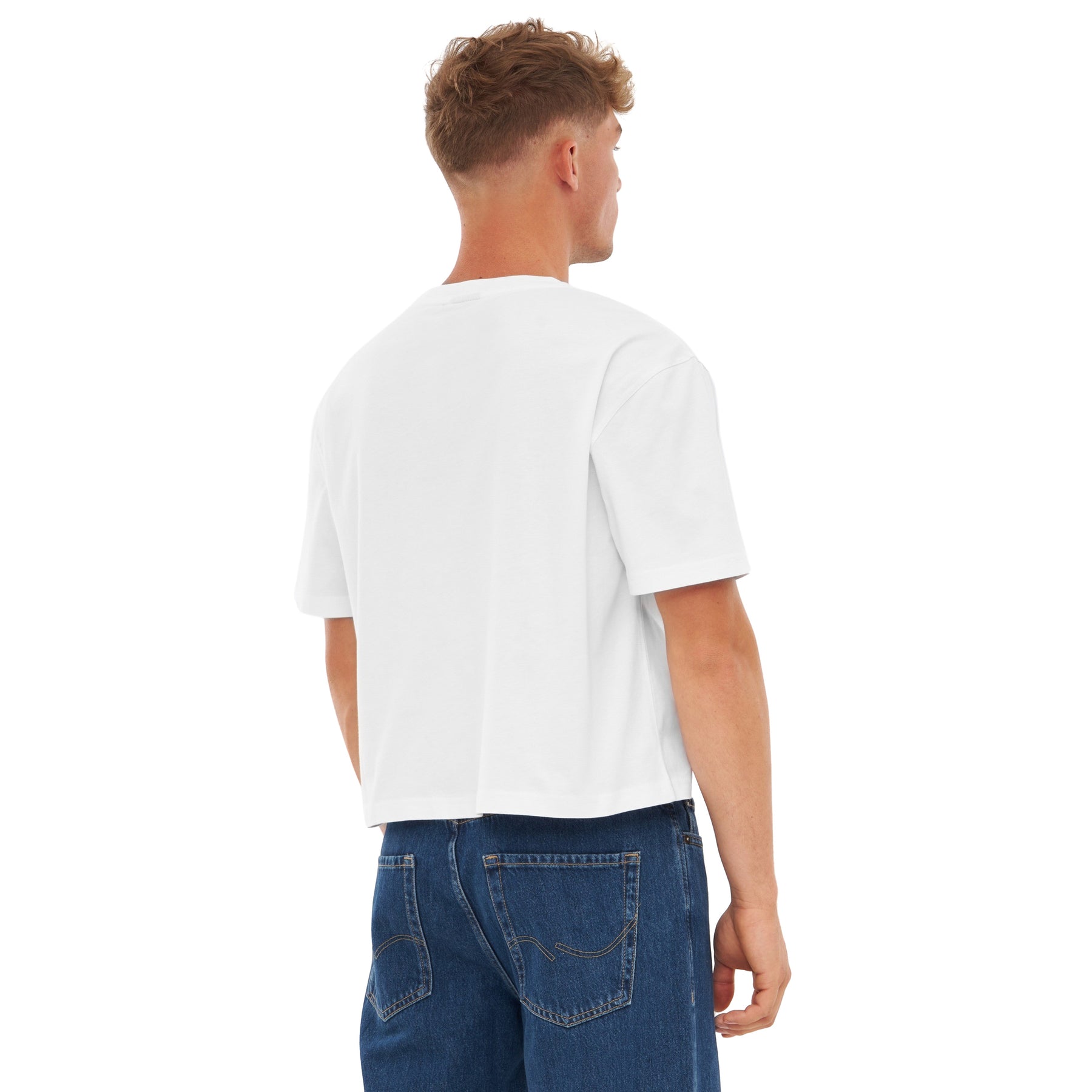 Mann trägt weißes oversize Cropped T-Shirt 'Zoey' von hinten, kombiniert mit blauen Jeans