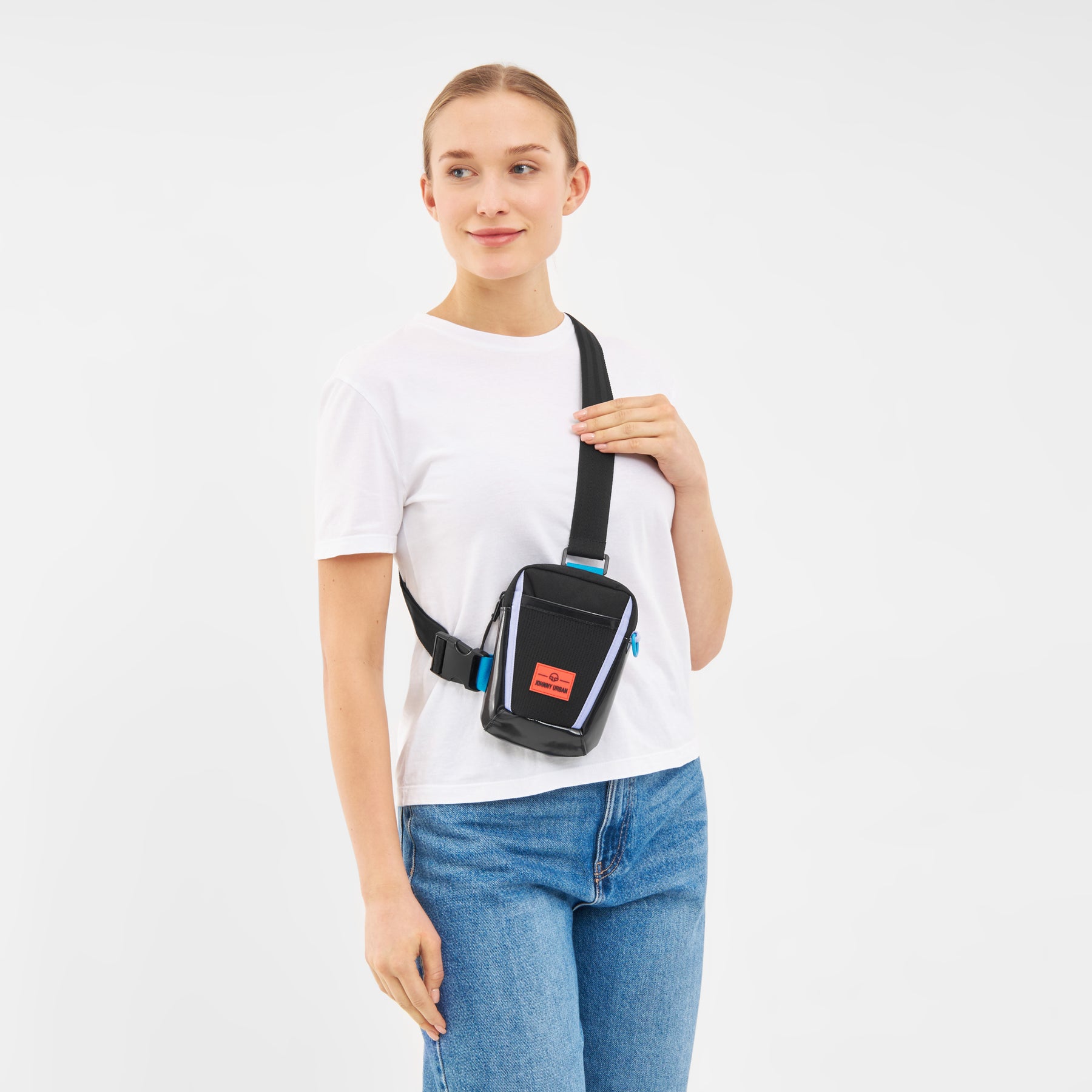 Frau trägt die schwarze Umhängetasche 'Lex' von Johnny Urban vorne über der Schulter, weiße T-Shirt und blaue Jeans