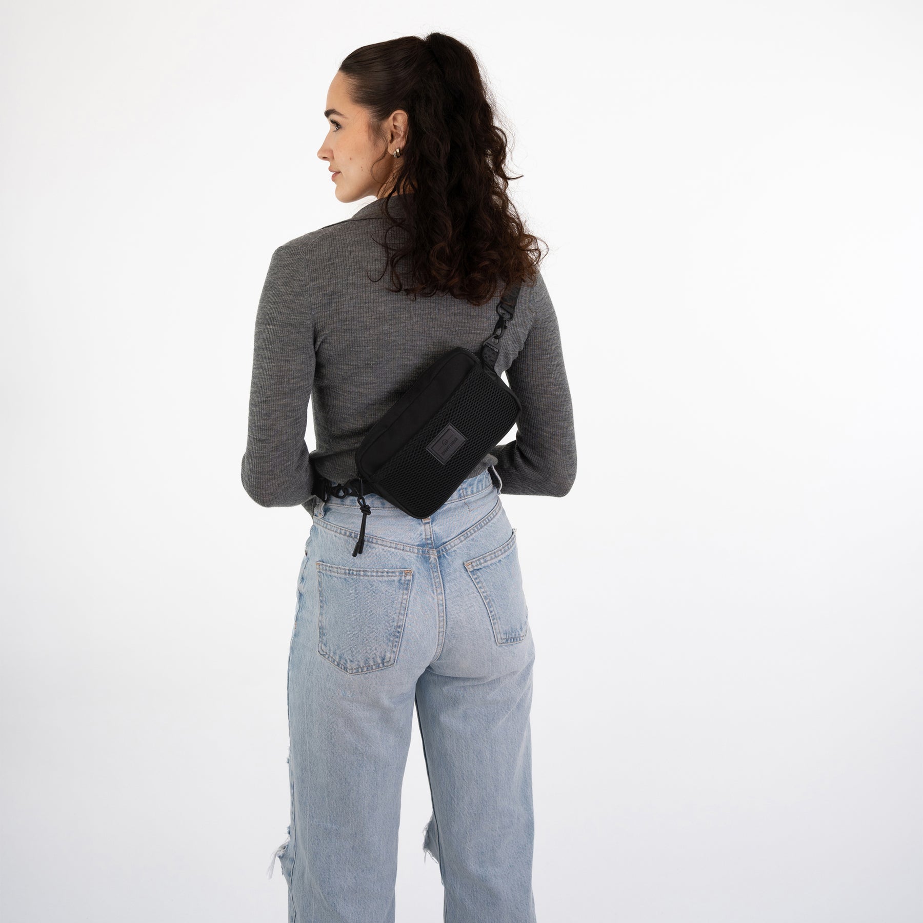 Frau von hinten mit schwarzer Umhängetasche 'Elliot' von Johnny Urban quer über dem Rücken