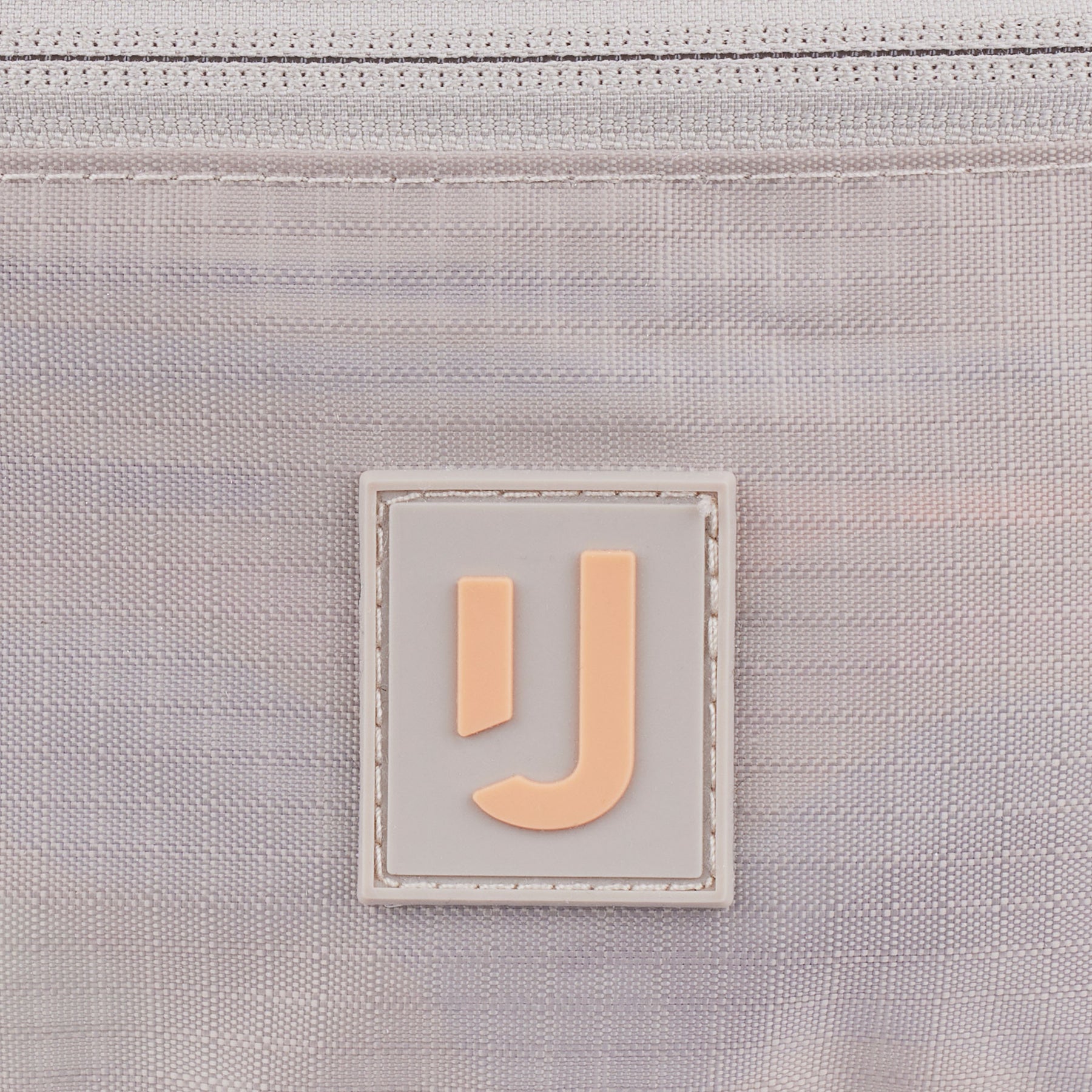 Nahe Aufnahme des Logos auf der wasserabweisenden 2in1 Bauchtasche 'Jimmy' von Johnny Urban