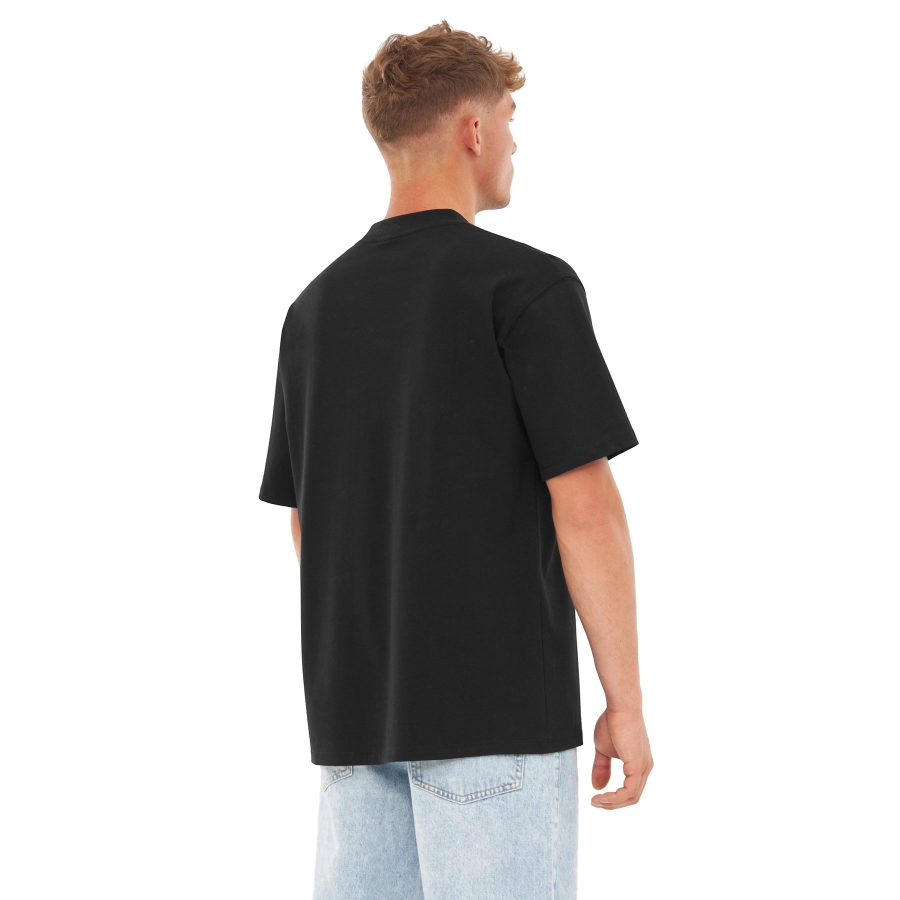 Mann trägt schwarzen Oversized-T-Shirt 'Sammy Johnny Urban' von hinten mit hellen Jeans