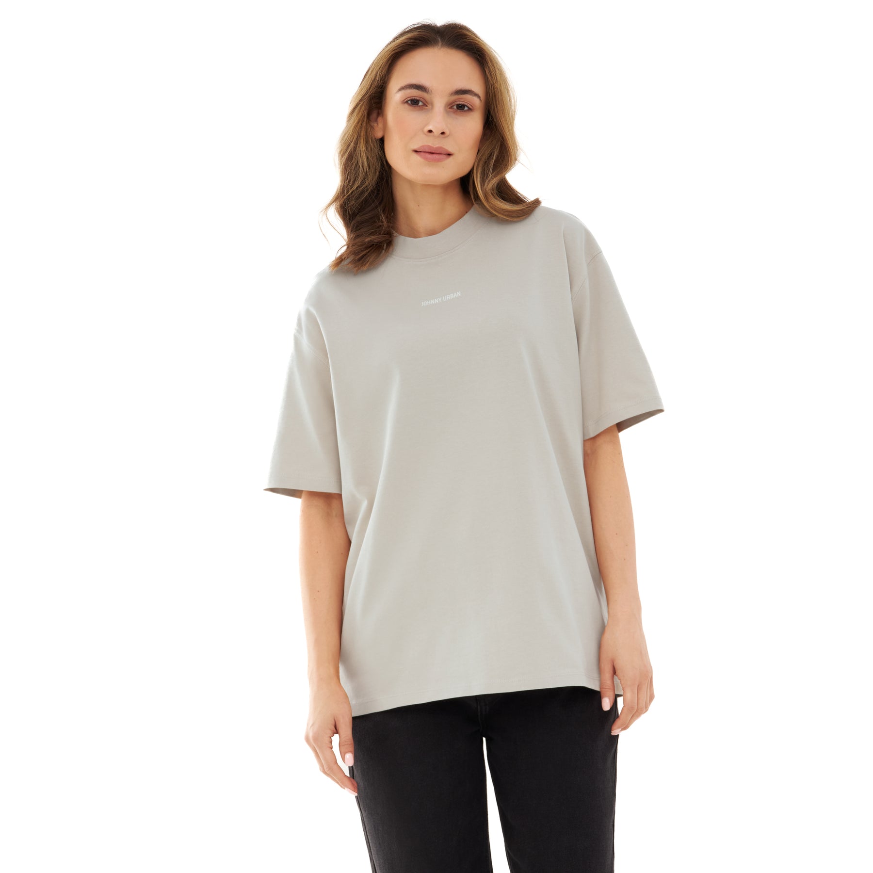 Frau trägt beige oversized T-Shirt 'Sammy Johnny Urban' mit kurzem Ärmel und schwarzer Hose