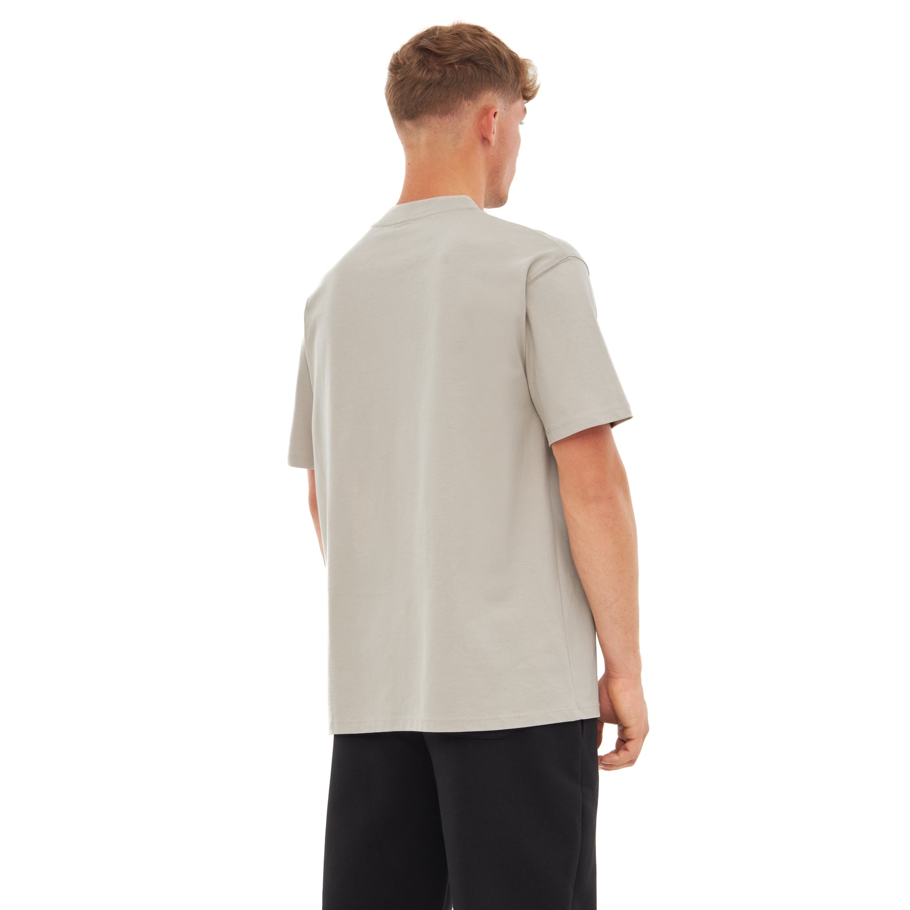 Rückansicht eines Mannes mit sandfarbenem T-Shirt 'Sammy Johnny Urban' und schwarzen Hosen