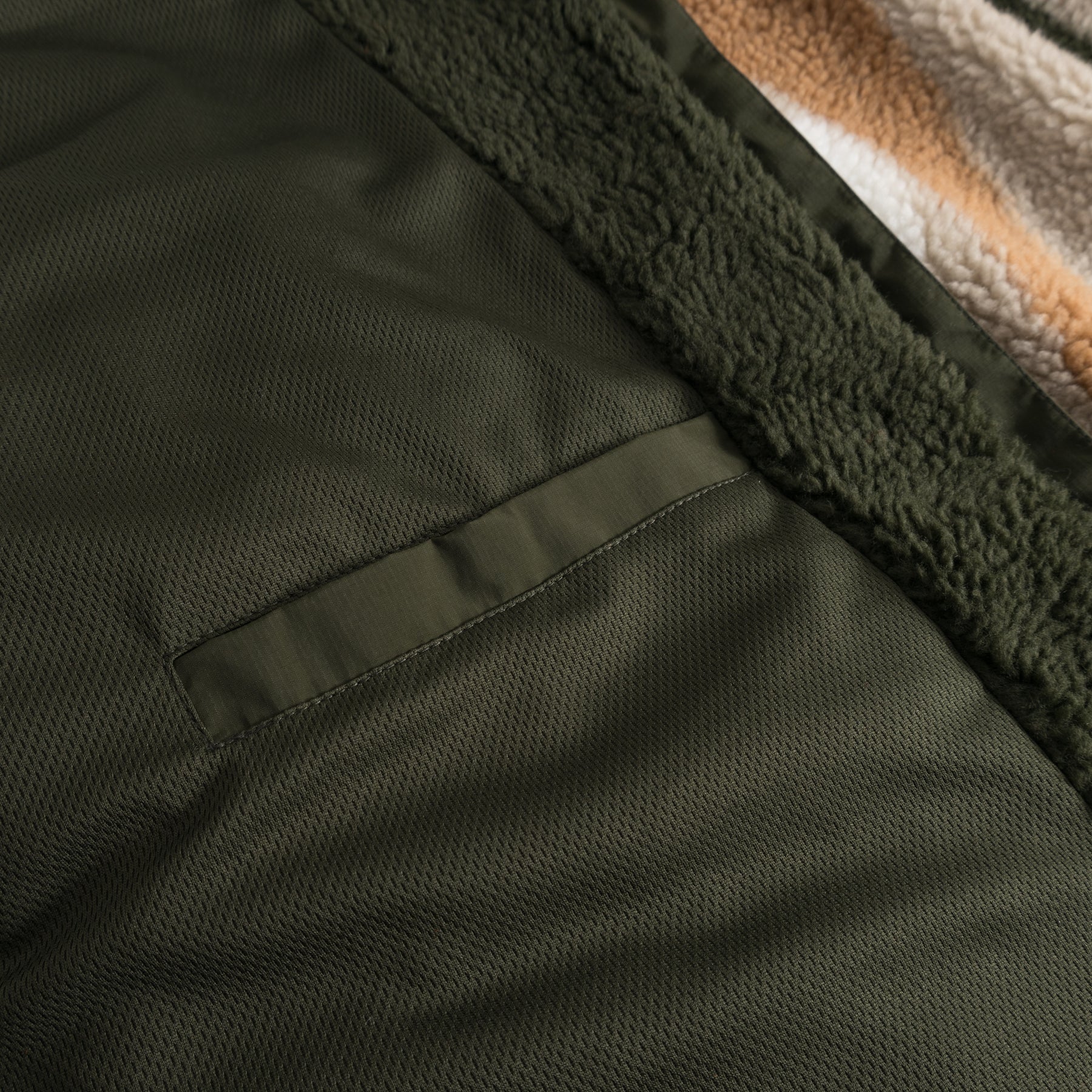 Detailaufnahme der dunkelolivgrünen Innen- und Fleeceaußenseite der Teddy Fleecejacke 'Carson'