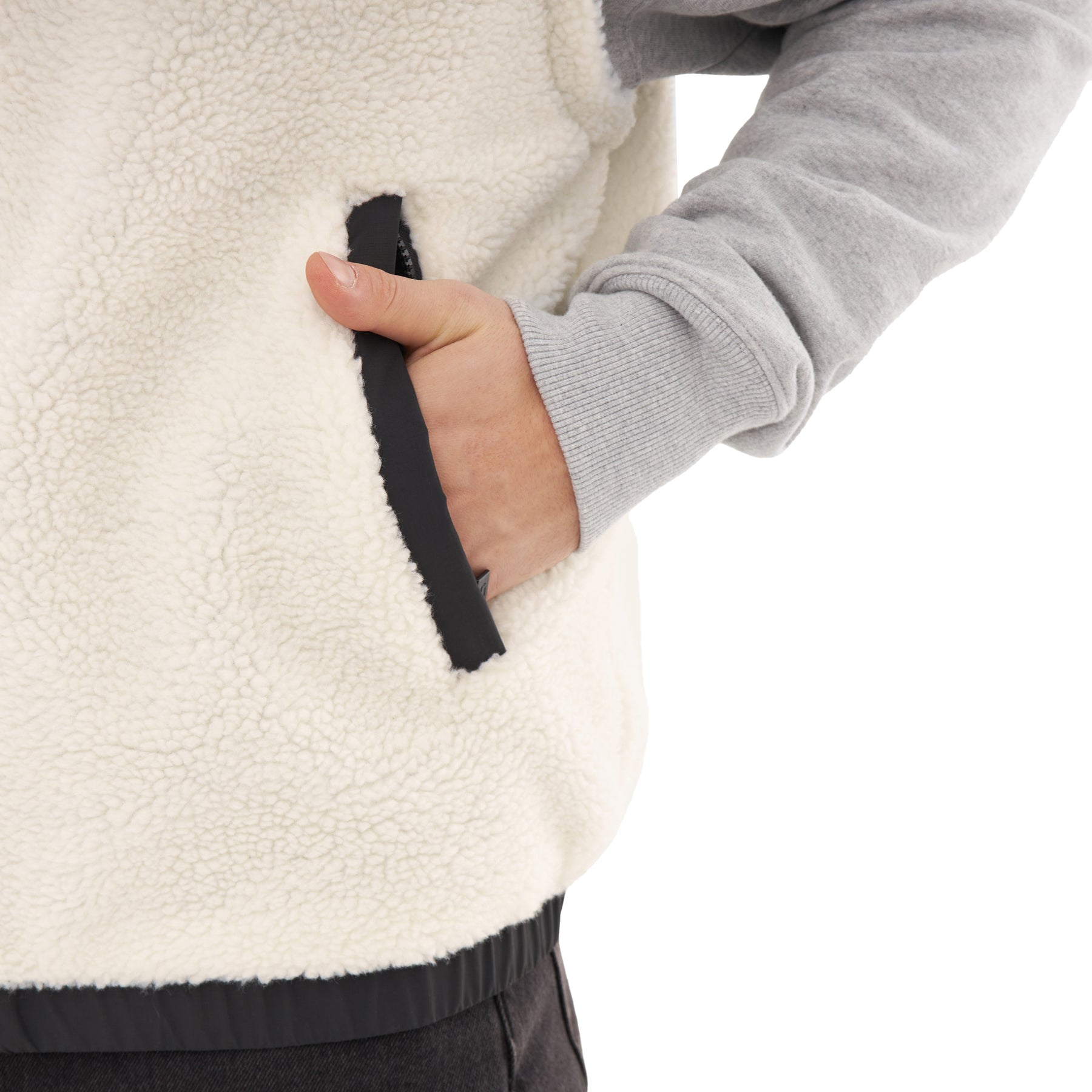 Hand steckt in Seitentasche der cremefarbenen Teddy Fleeceweste 'Bryson'