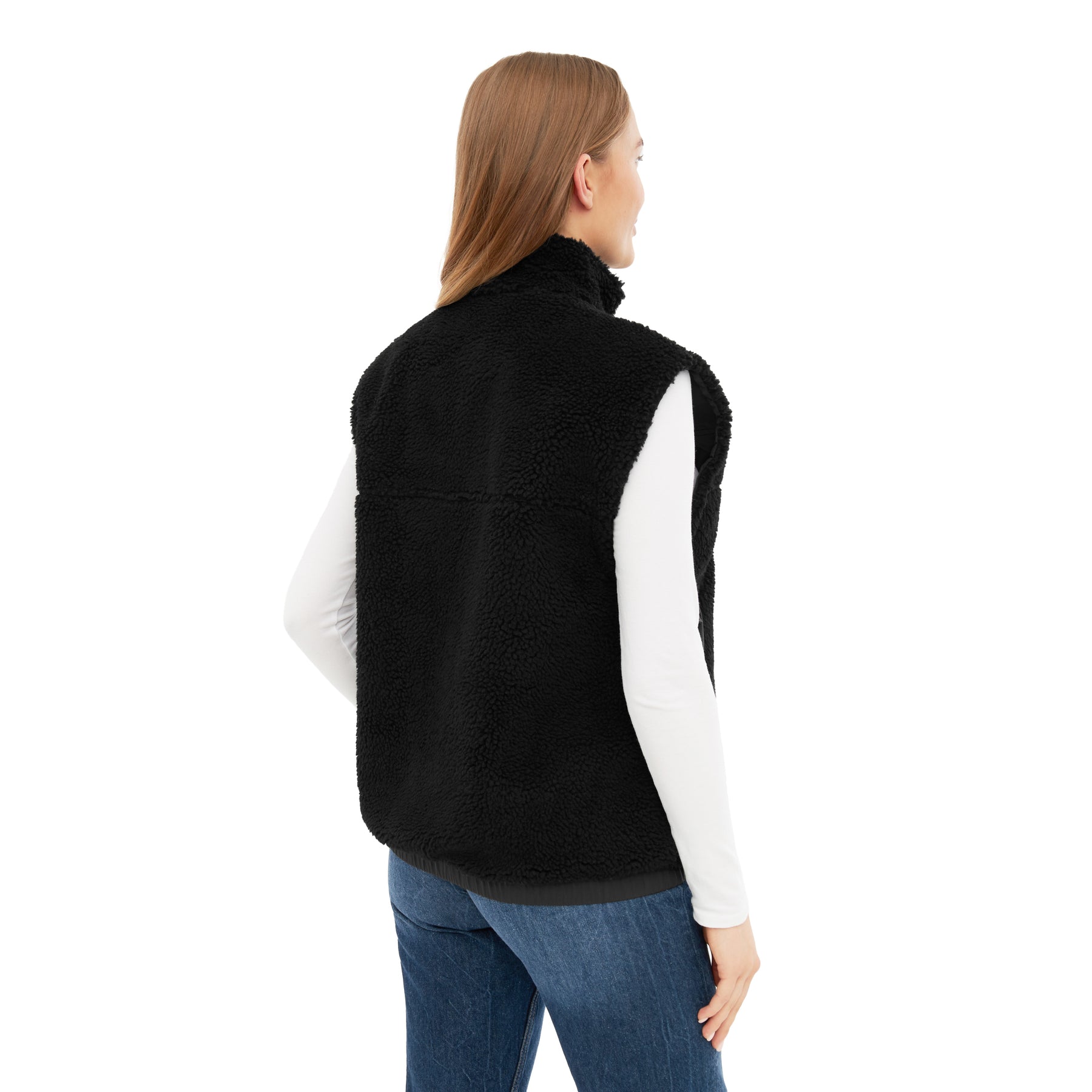 Rückansicht einer Frau mit schwarzer Teddy Fleeceweste 'Bryson' über weißem Oberteil und blauen Jeans
