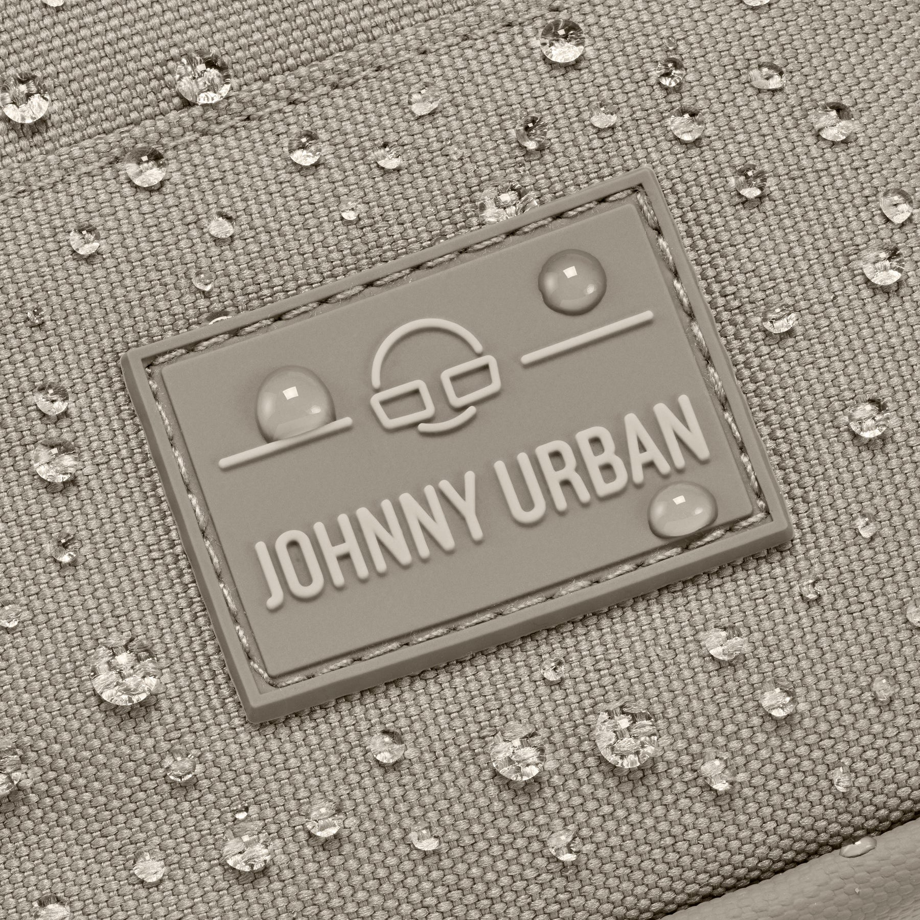 Nahaufnahme des wasserabweisenden Front Packs 'Arthur' von Johnny Urban mit sichtbaren Wassertropfen