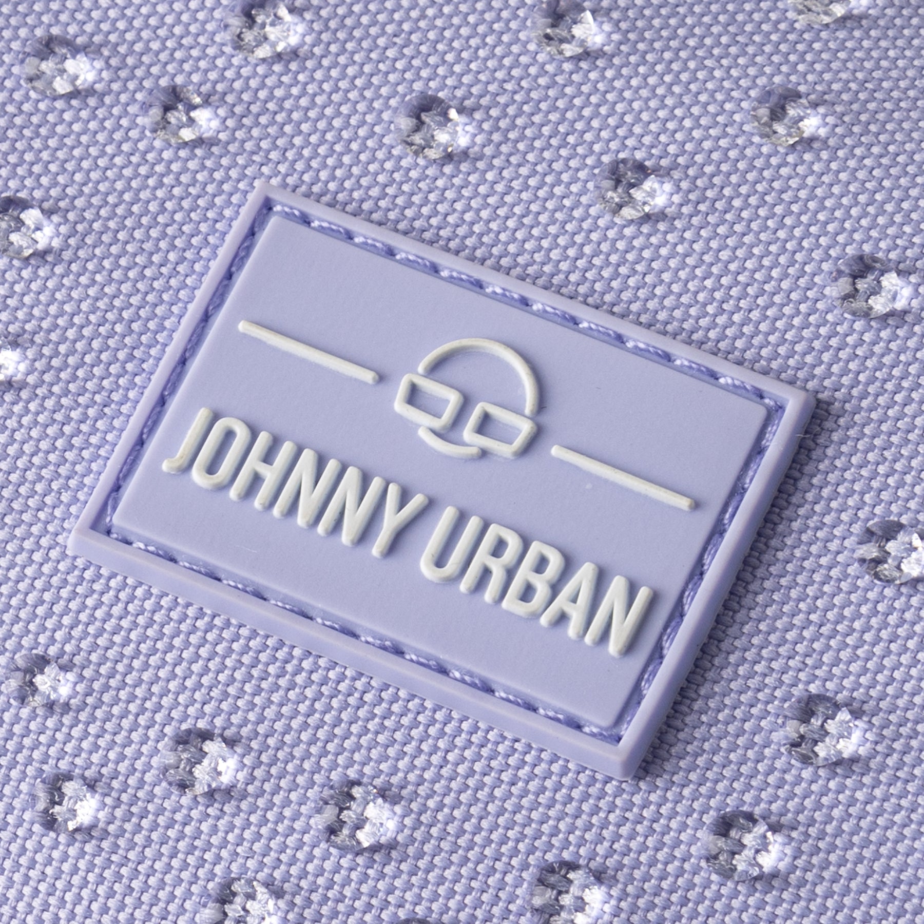 Nahaufnahme des Johnny Urban Logos auf wasserabweisendem lila Stoff der Half Moon Bag 'Ally Small'