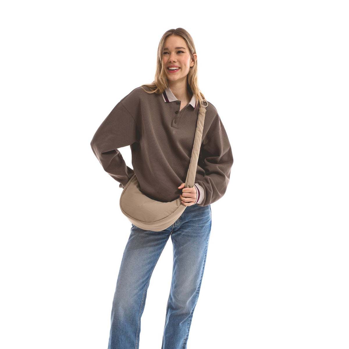 Unser weibliches Model präsentiert sich hier mit der Half-Moon-Bag "Lou Medium" in beige.