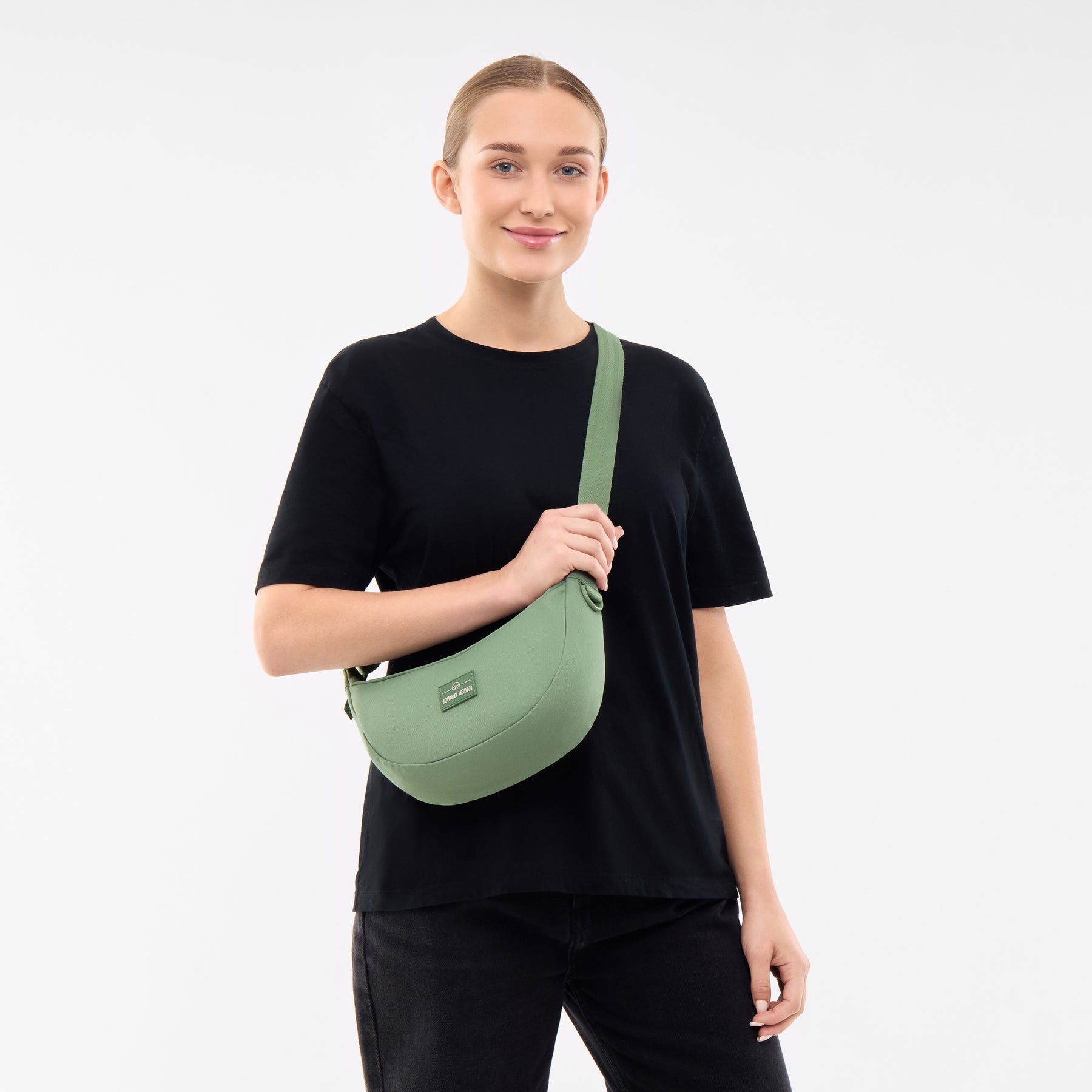 Frau trägt die sage-grüne Half Moon Bag 'Ally Small' von Johnny Urban quer am Körper
