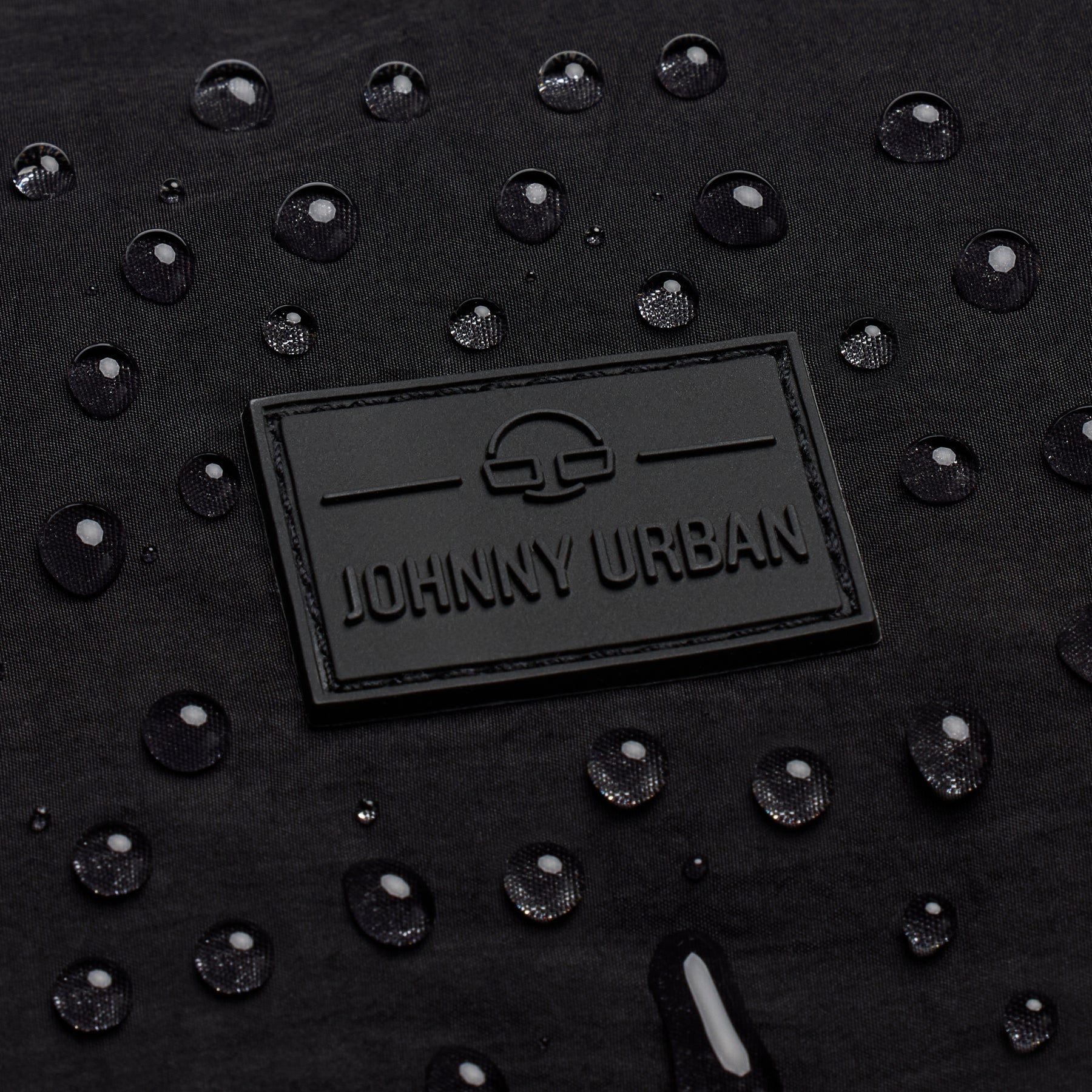 Wasserabweisendes schwarzes Material der Half Moon Bag 'Kaia Medium' mit Johnny Urban Logo und Wassertropfen