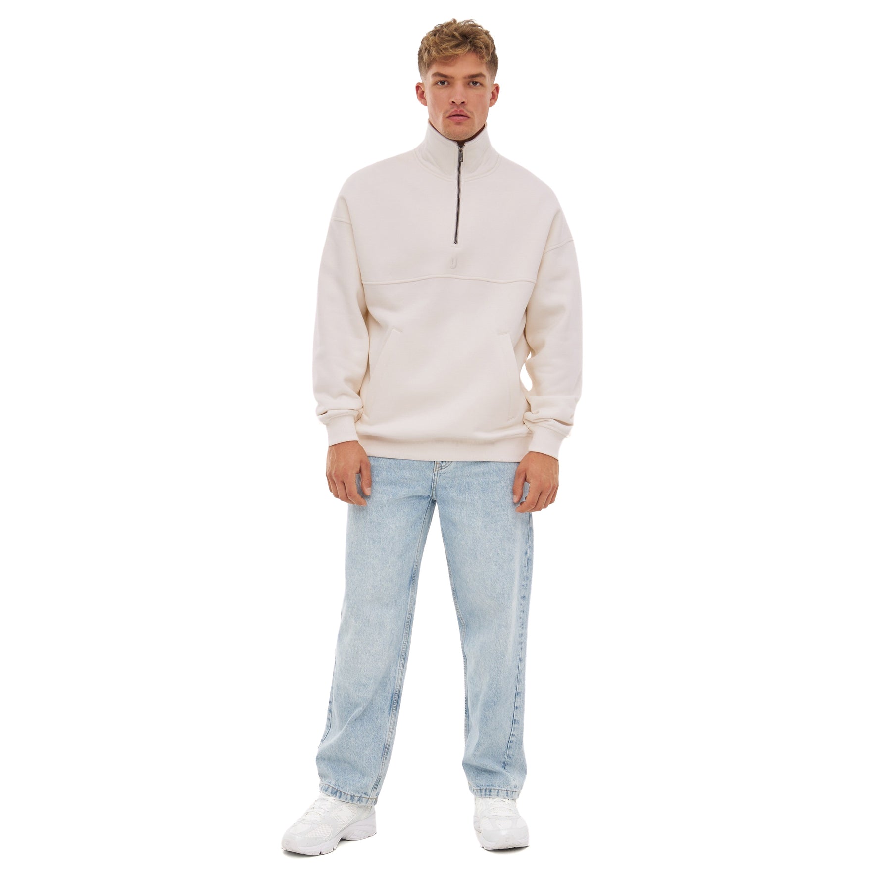 Herren trägt cremeweißen Half Zip Sweatshirt 'Cooper' mit Reißverschluss bis zur Brust und hellblaue Jeans