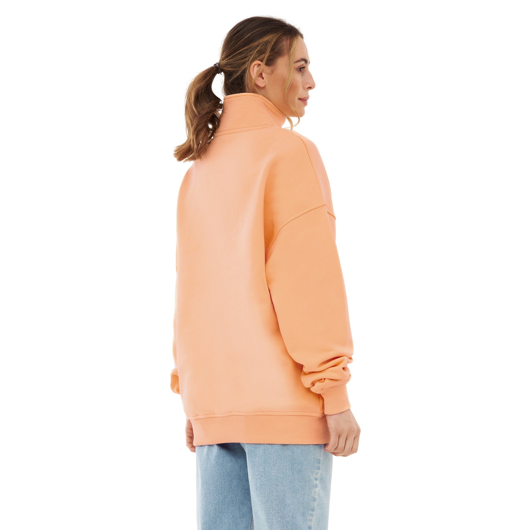 Frau trägt pfirsichfarbenen Half Zip Sweatshirt 'Cooper' von Johnny Urban, Rückansicht, dazu blaue Jeans
