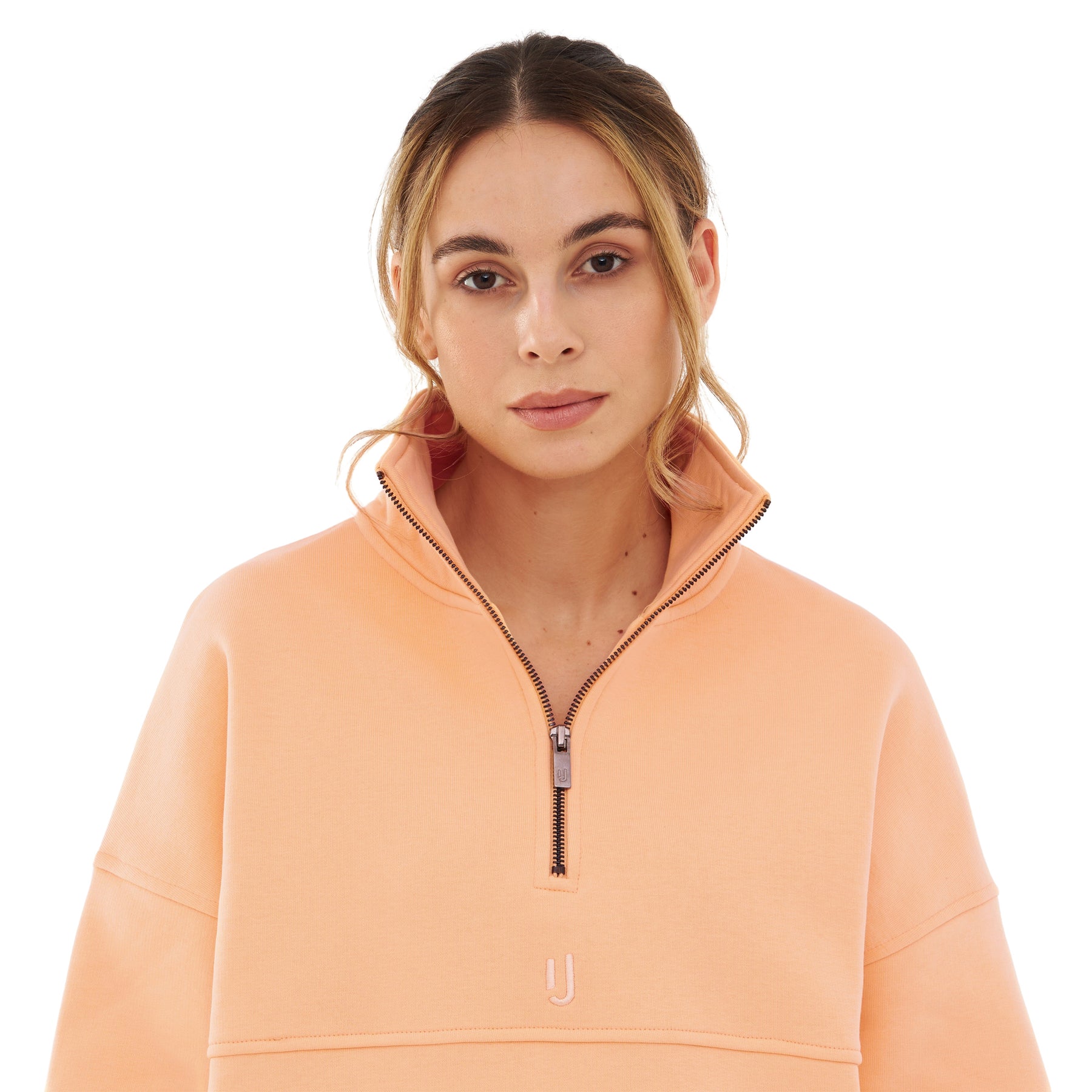 Frau trägt Half Zip Sweatshirt 'Cooper' von Johnny Urban in pfirsich, mit hohem Kragen und halbem Reißverschluss