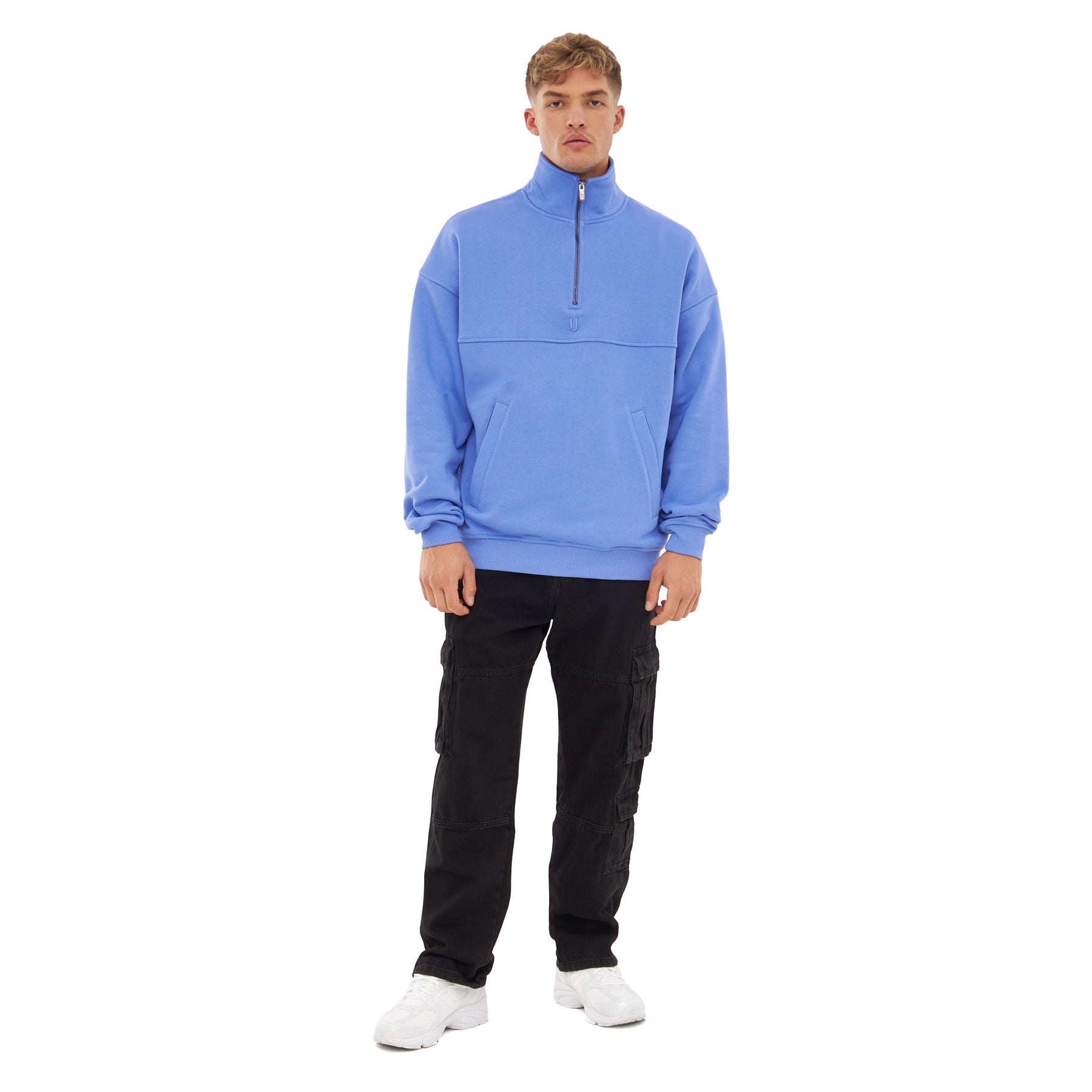 Mann trägt hellblauen Half-Zip Sweatshirt 'Cooper' mit hohem Kragen und Reißverschluss, schwarze Cargohose, weiße Turnschuhe