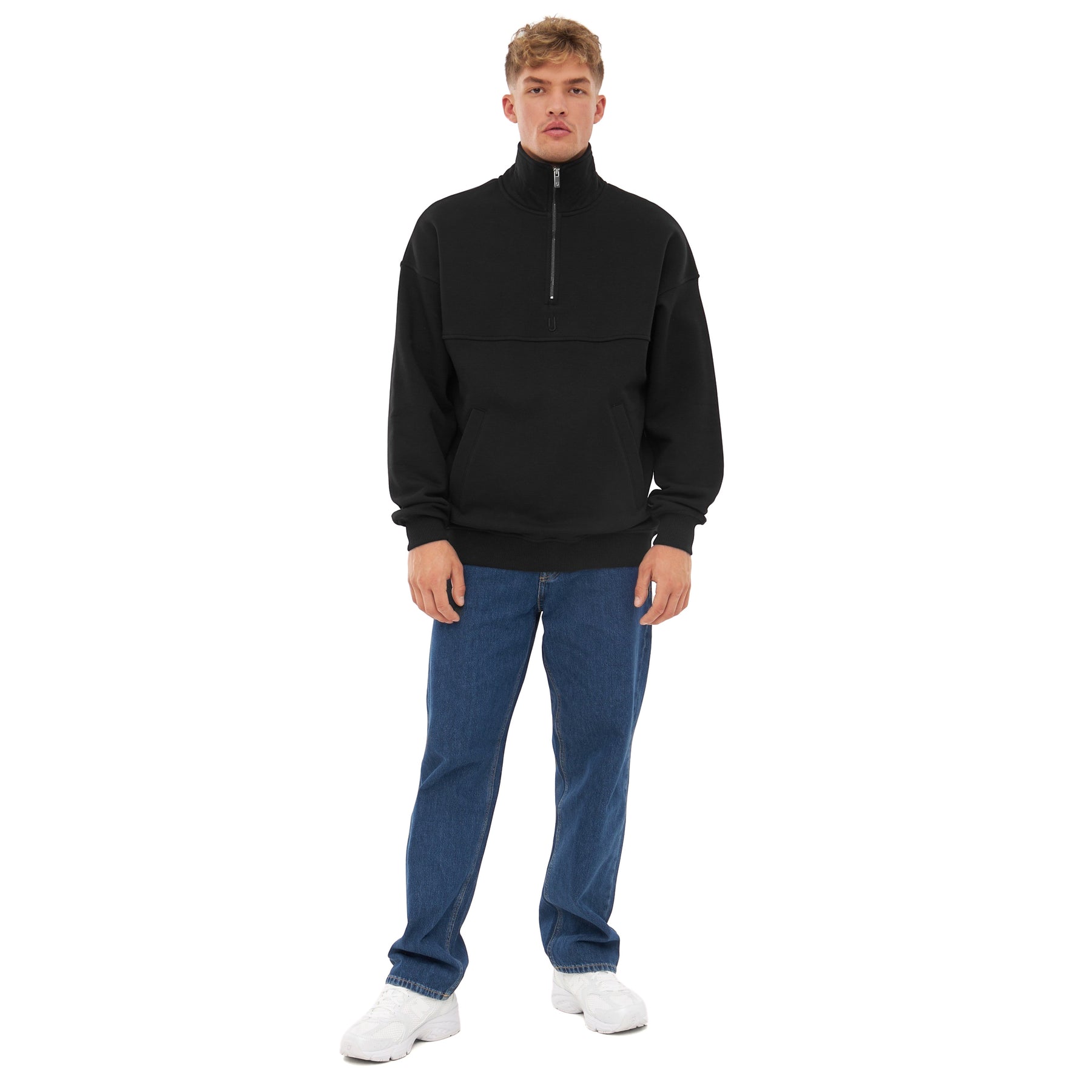 Mann trägt schwarzen Half Zip Sweatshirt Pullover 'Cooper', blaue Jeans und weiße Sneaker