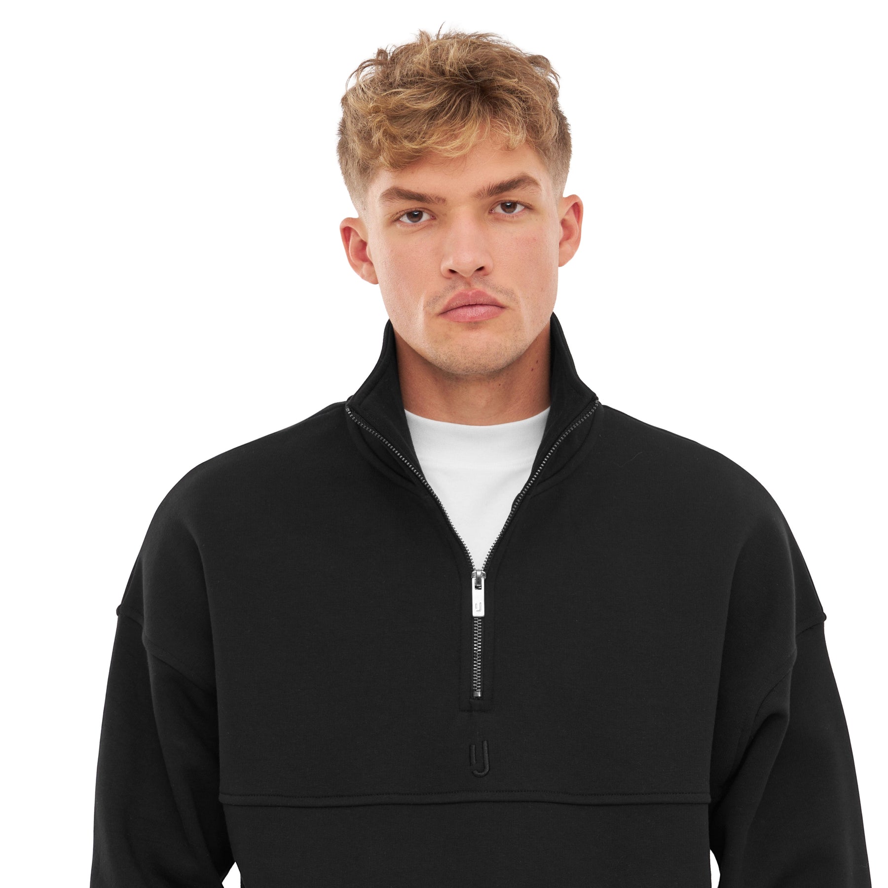 Mann trägt schwarzen Half Zip Sweatshirt 'Cooper' mit halb offenem Reißverschluss und weißem Unterhemd
