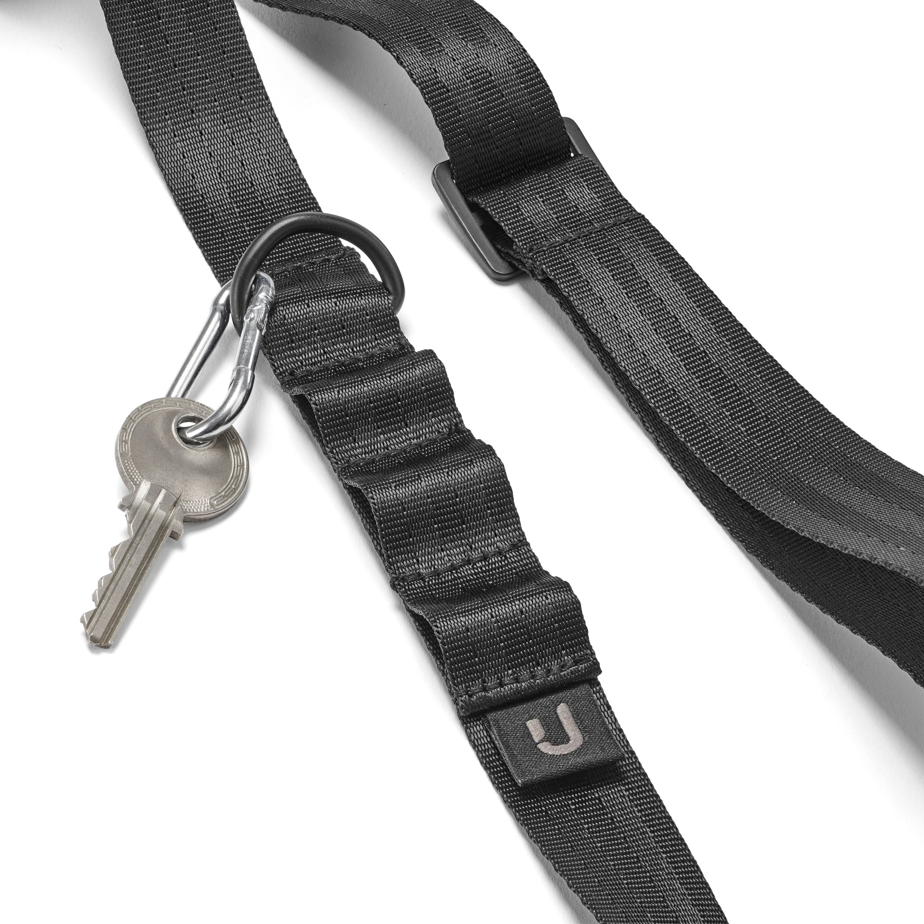 Schwarze Handyschlaufe aus Nylon mit verstellbarem Riemen und Metallkarabiner, an dem ein Schlüssel hängt