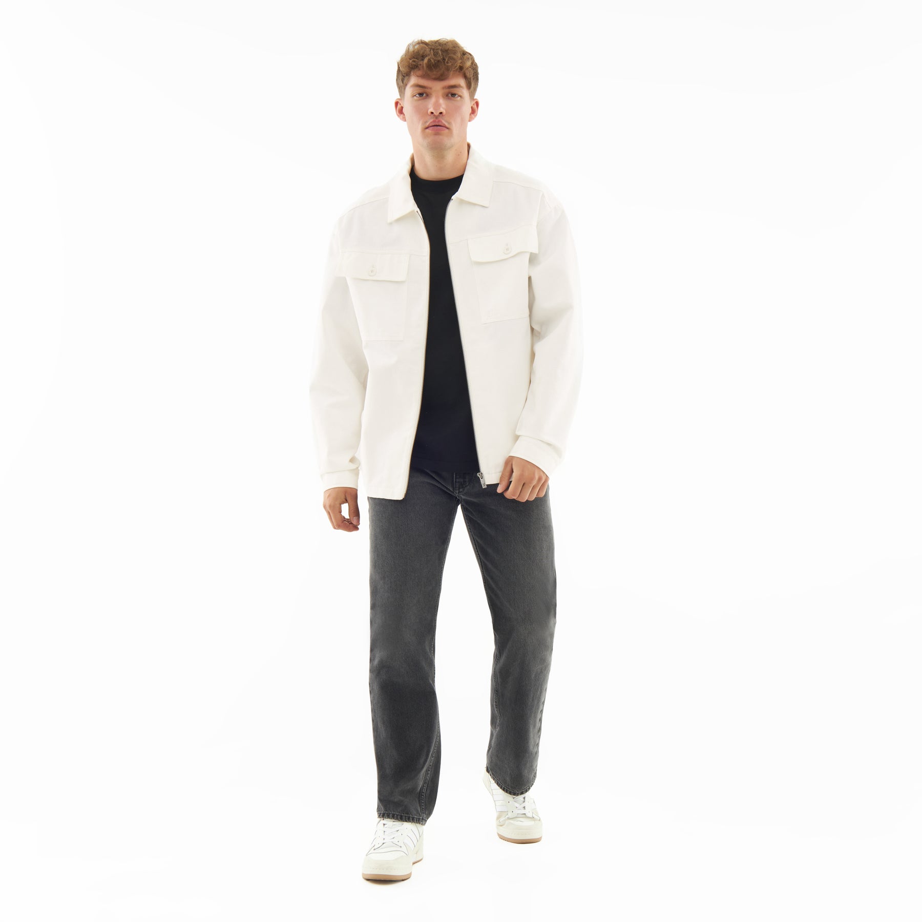 Mann trägt cremefarbene Overshirt 'Cameron' aus Baumwolle, kombiniert mit dunklen Jeans und weißen Schuhen