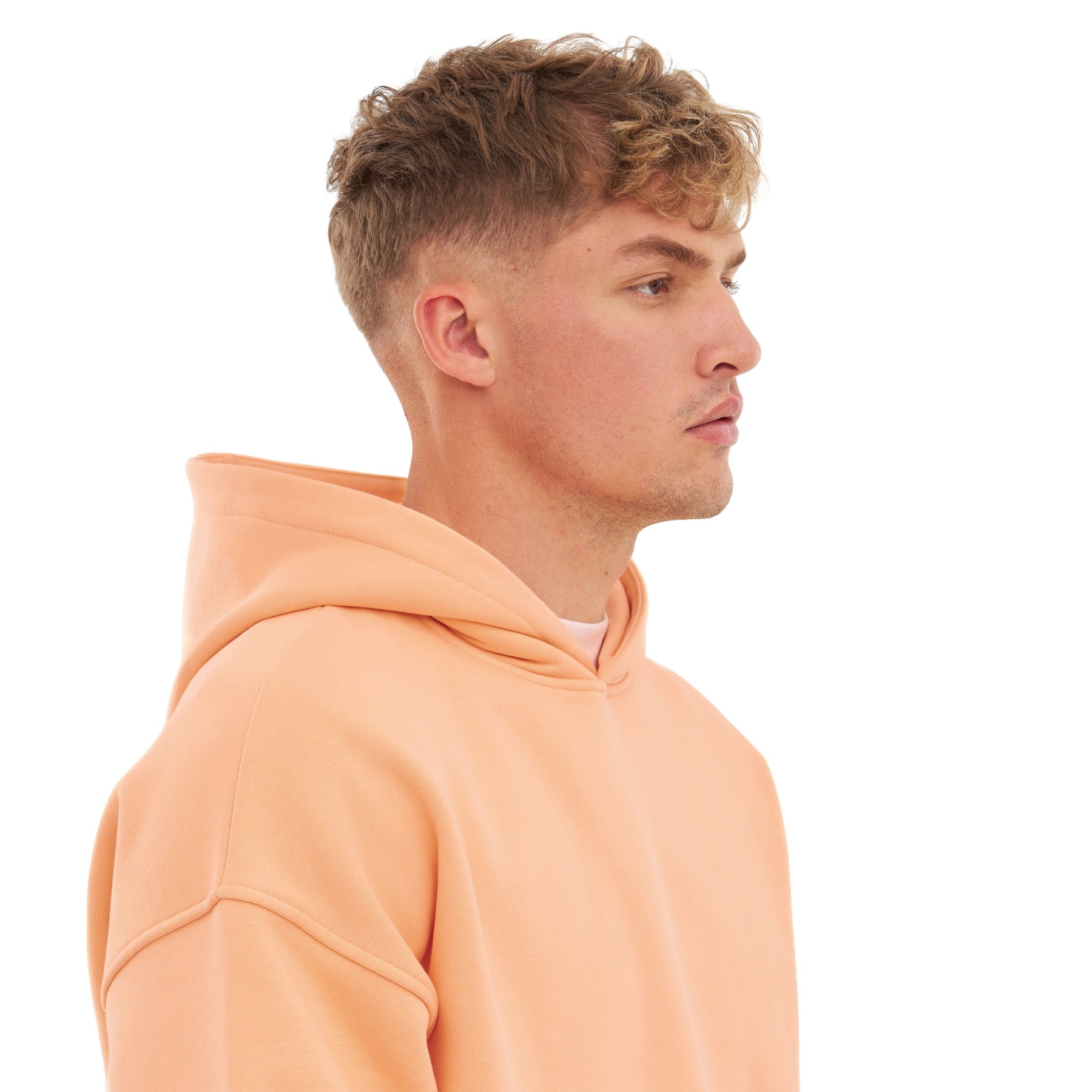 Mann im Profil trägt oversized Hoodie 'Cody' in Pfirsichfarbe mit Kapuze