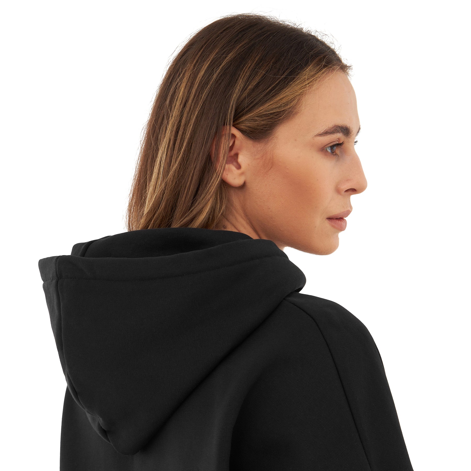 Frau mit mittelbraunen Haaren trägt Oversized Hoodie 'Cody' in Schwarz, Blick nach rechts