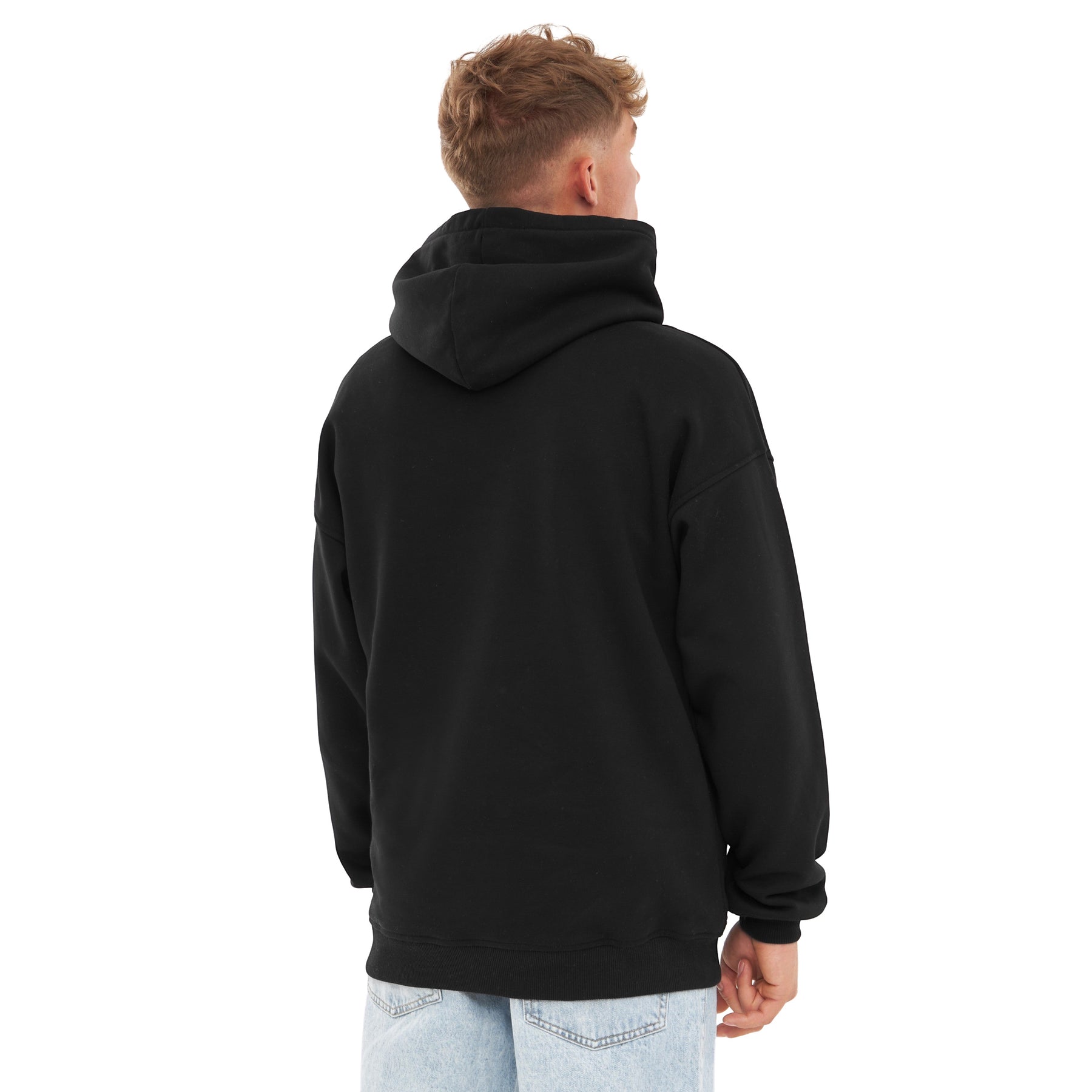 Mann trägt schwarzen Oversized Hoodie 'Cody' von hinten, dazu helle Jeans