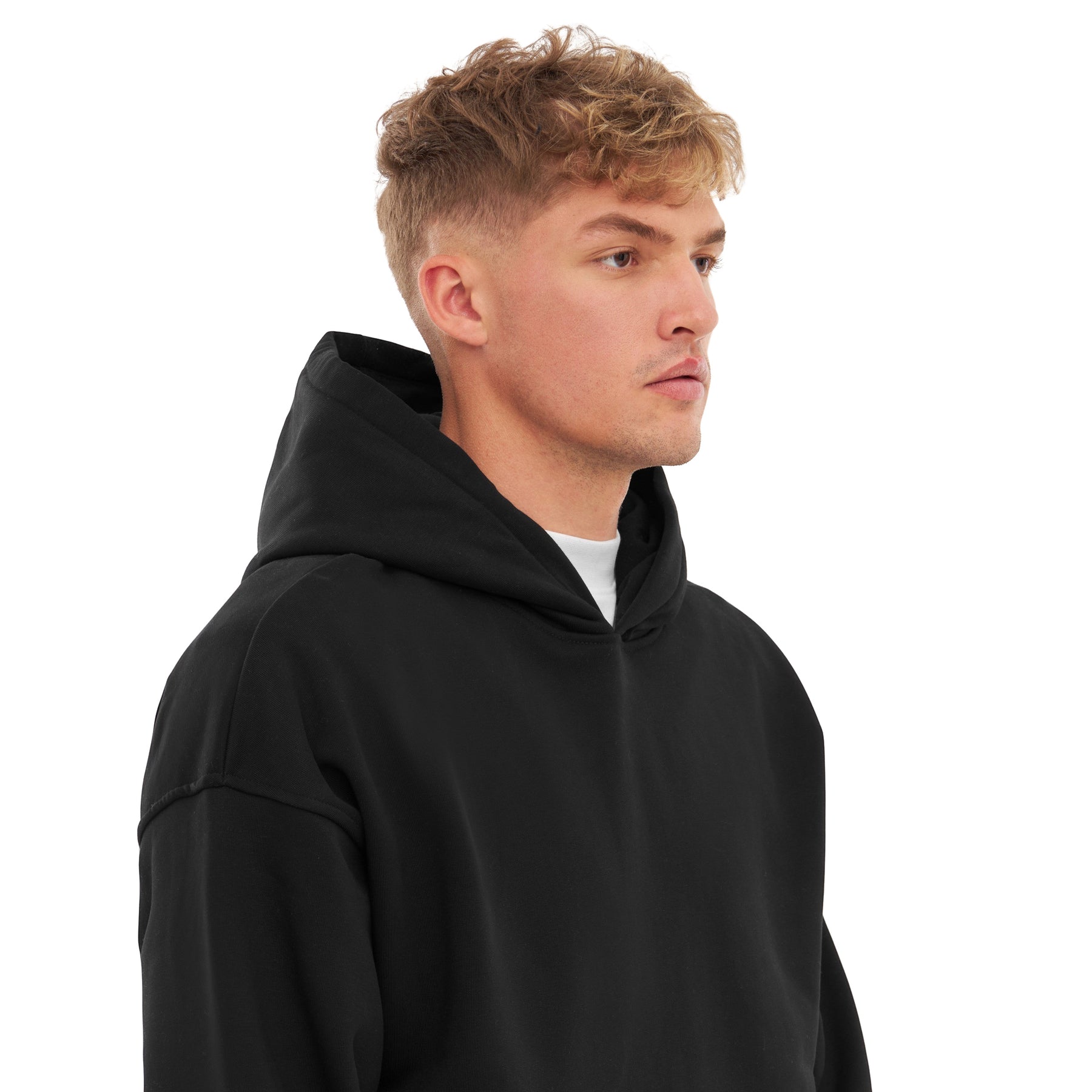 Mann mit kurz blondem Haar trägt schwarzen Oversized Hoodie 'Cody' von Johnny Urban