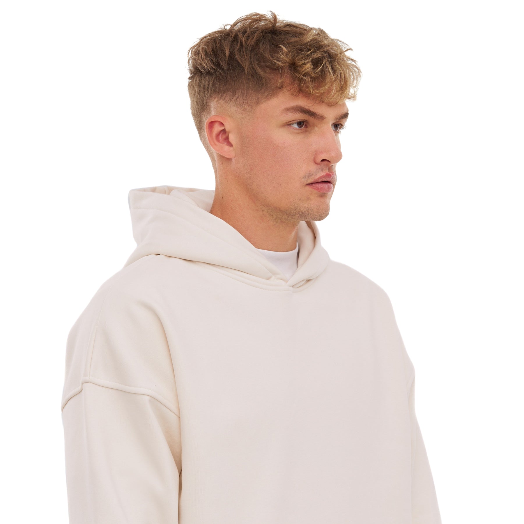 junger Mann mit kurzem lockigem Haar trägt weißen oversized Hoodie 'Cody'
