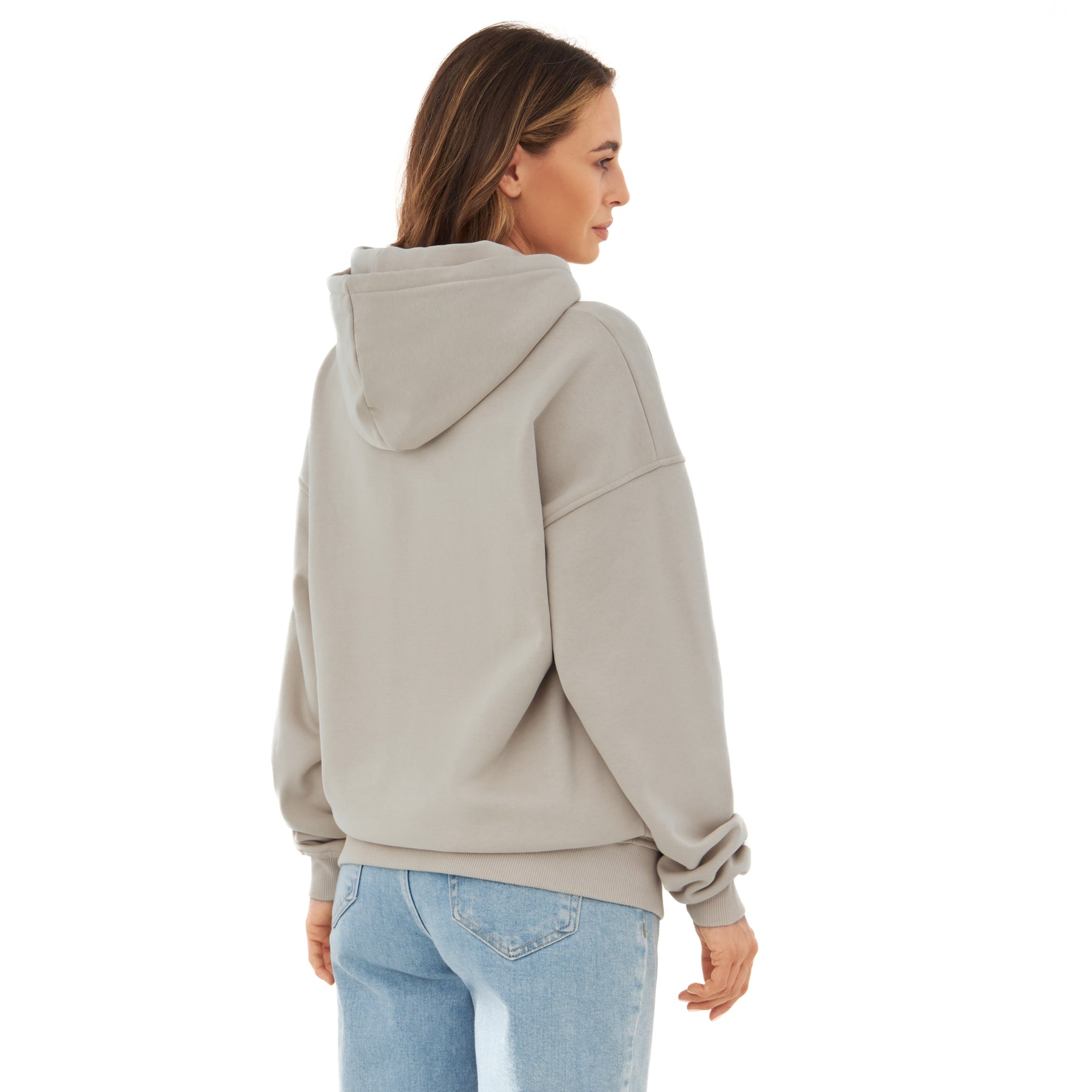 Frau trägt oversized Hoodie 'Cody' in hellem Beige, Rückansicht, kombiniert mit hellblauen Jeans