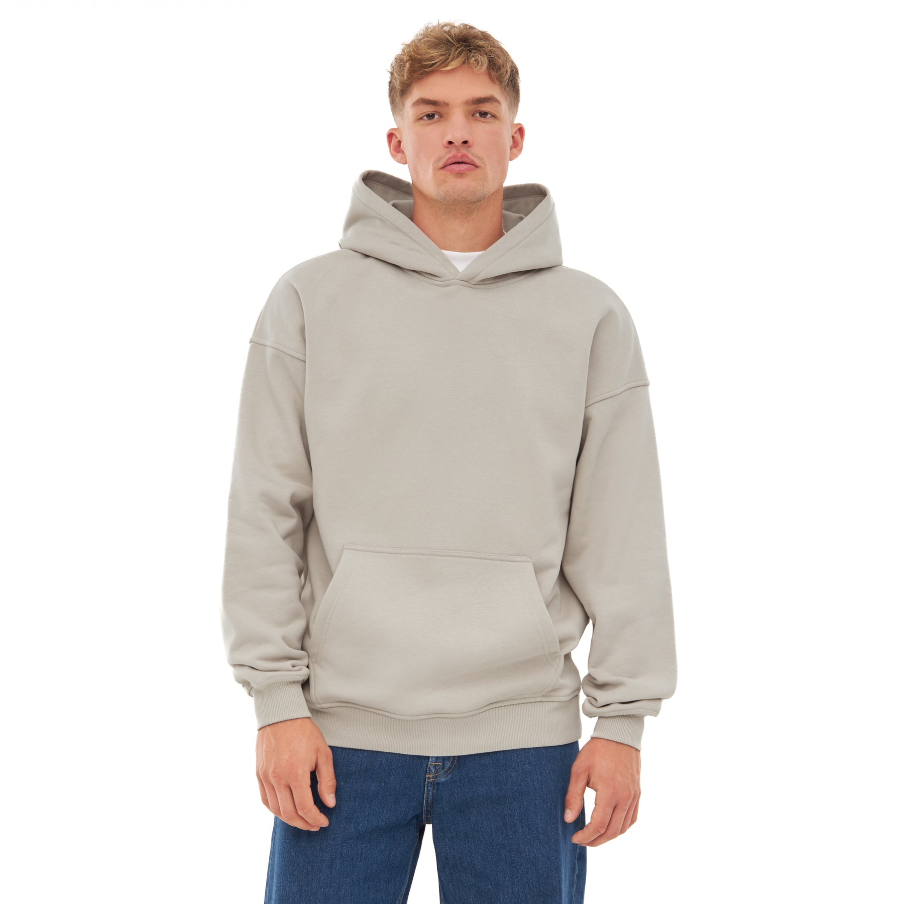 Mann trägt oversized Hoodie 'Cody' in hellem Grau mit Kängurutasche und Kapuze