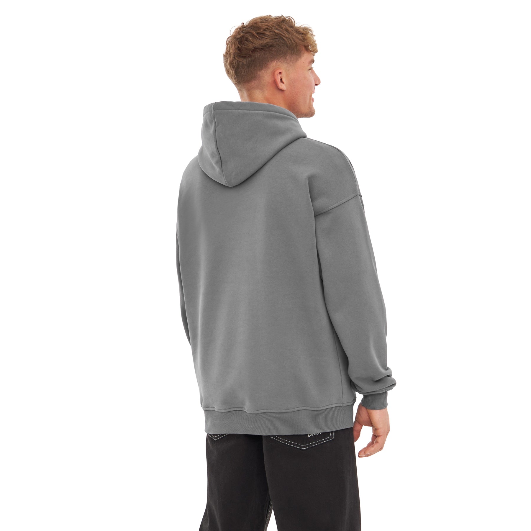 Mann von hinten in grauem oversized Hoodie 'Cody' mit Kapuze, trägt schwarze Jeans