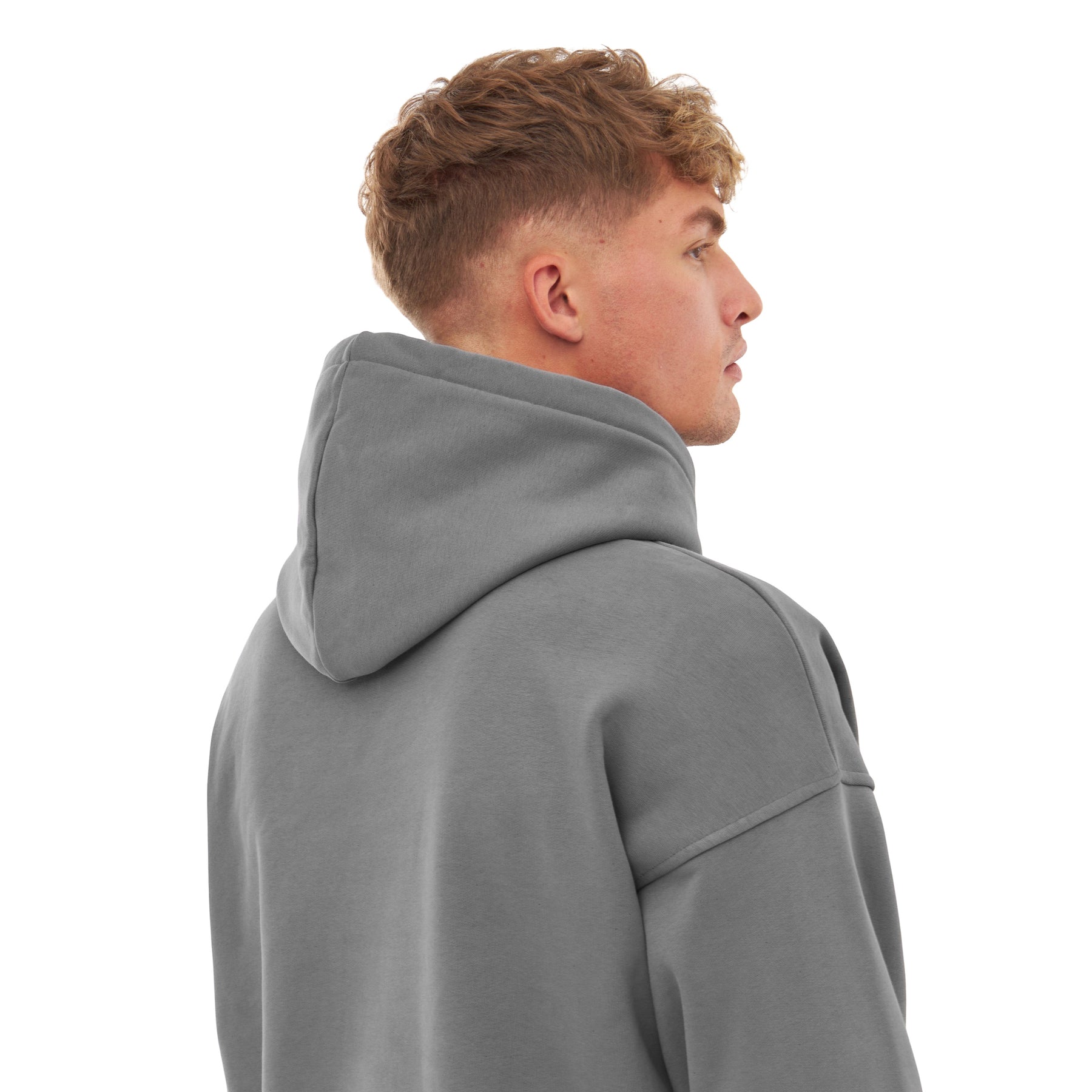 Männliches Modell von hinten mit oversized Hoodie 'Cody' in Grau, Kapuze hochgeklappt