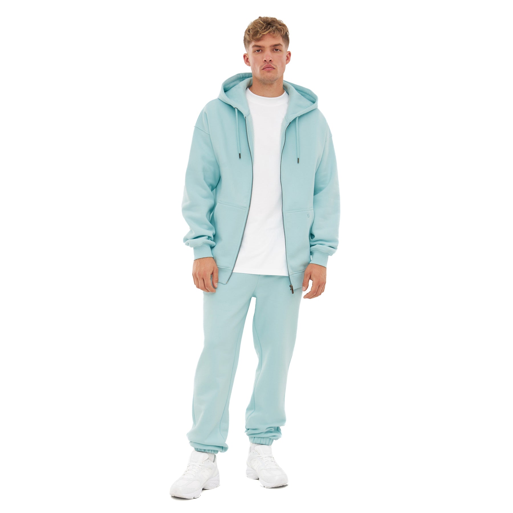 Mann trägt Jogginghose 'Owen' in ice-blau mit passendem Kapuzenpullover und weißem T-Shirt