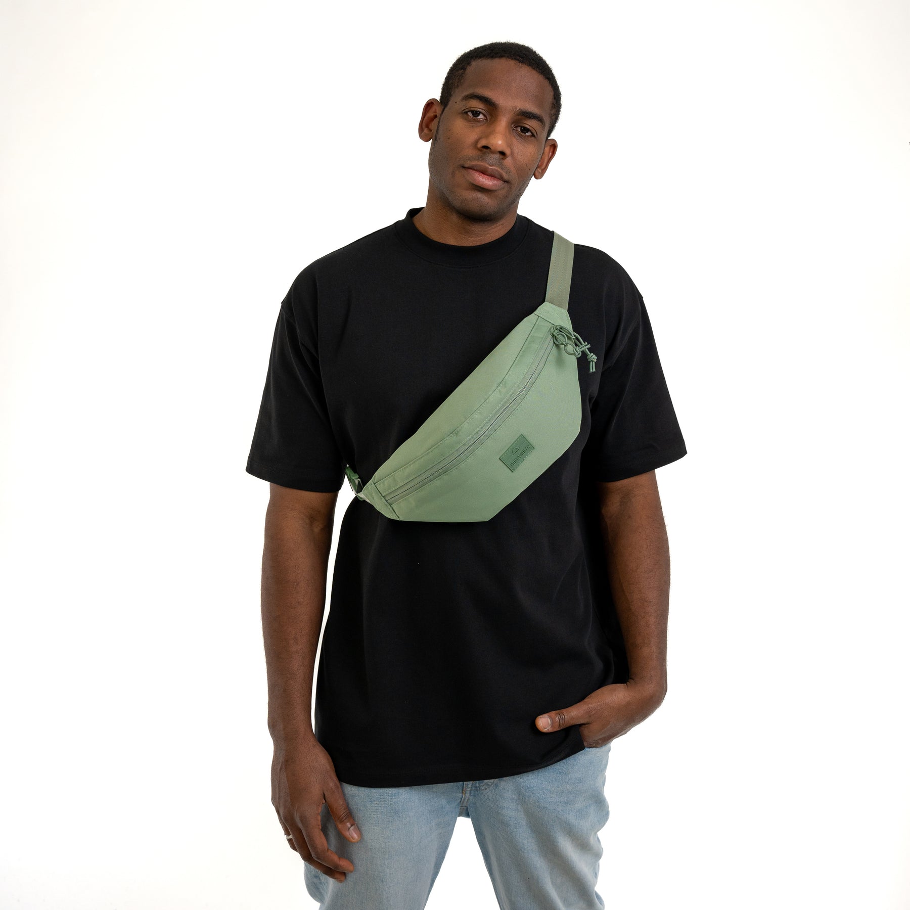 Mann trägt sagegrüne Bauchtasche 'Erik Large' von Johnny Urban über schwarzem T-Shirt