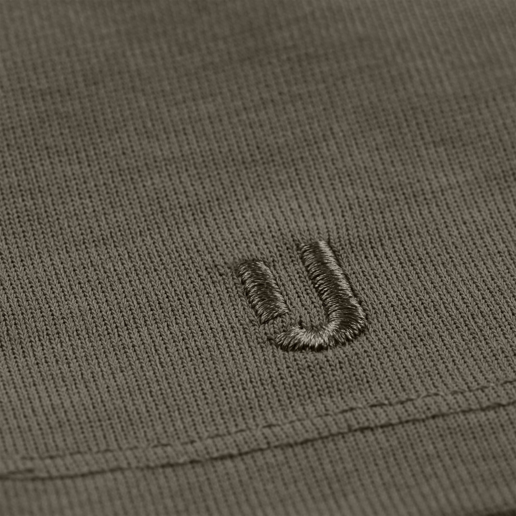 Nahaufnahme des grauen Stoffes mit gesticktem Johnny Urban Logo