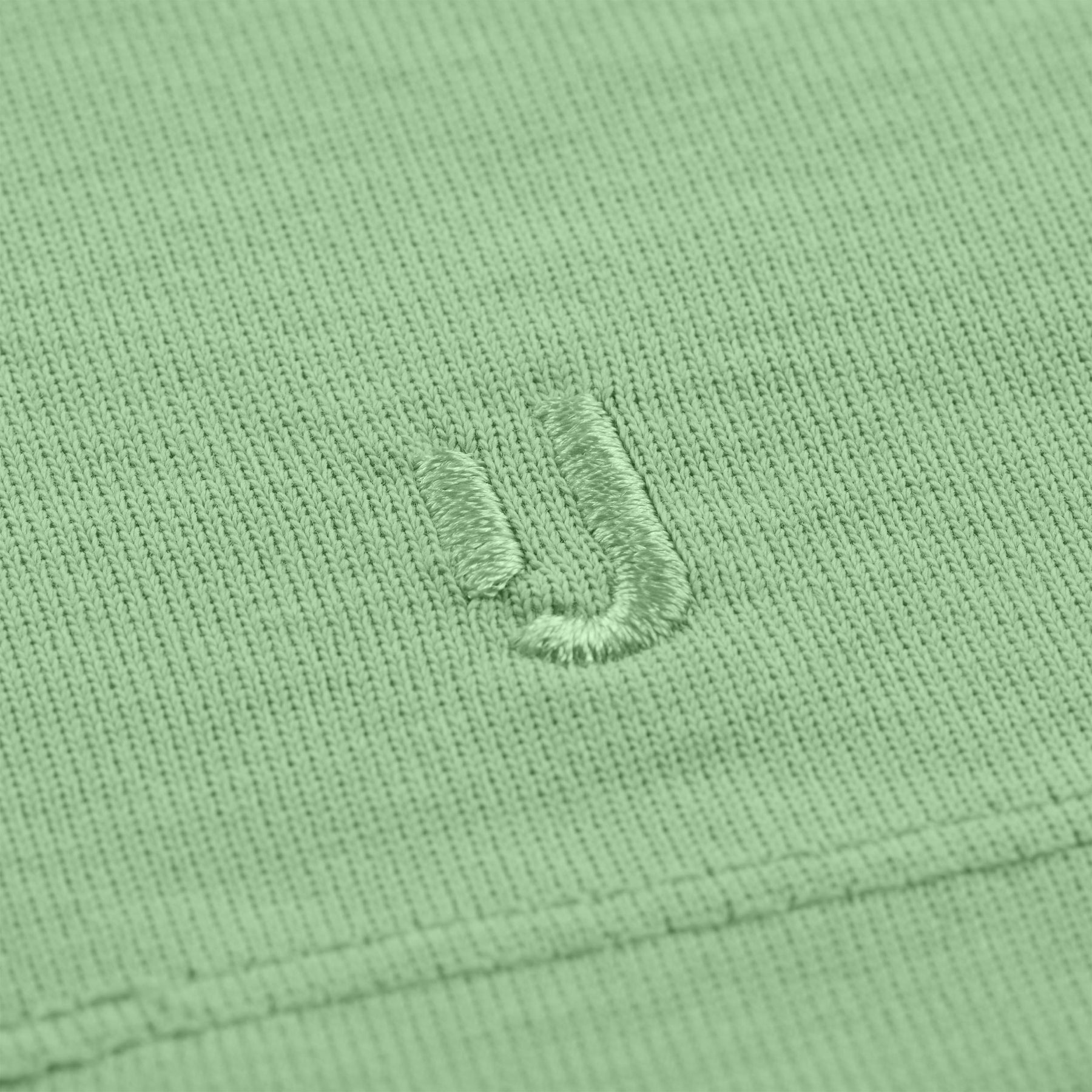 Nahaufnahme des gestickten Johnny Urban Logos auf dem T-Shirt 'Sammy' in Salbeigrün