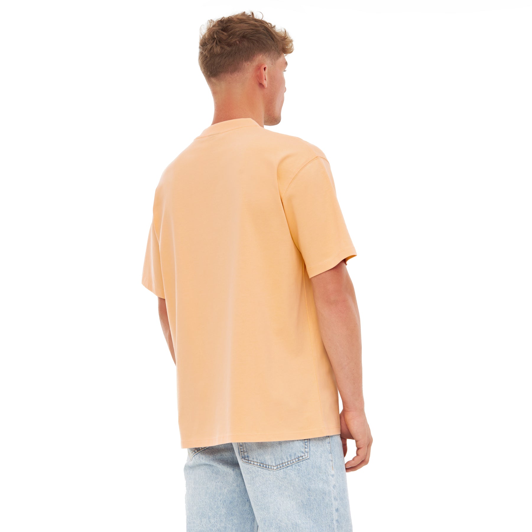 Herren trägt oversized T-Shirt 'Sammy' in Pfirsichfarbe von hinten