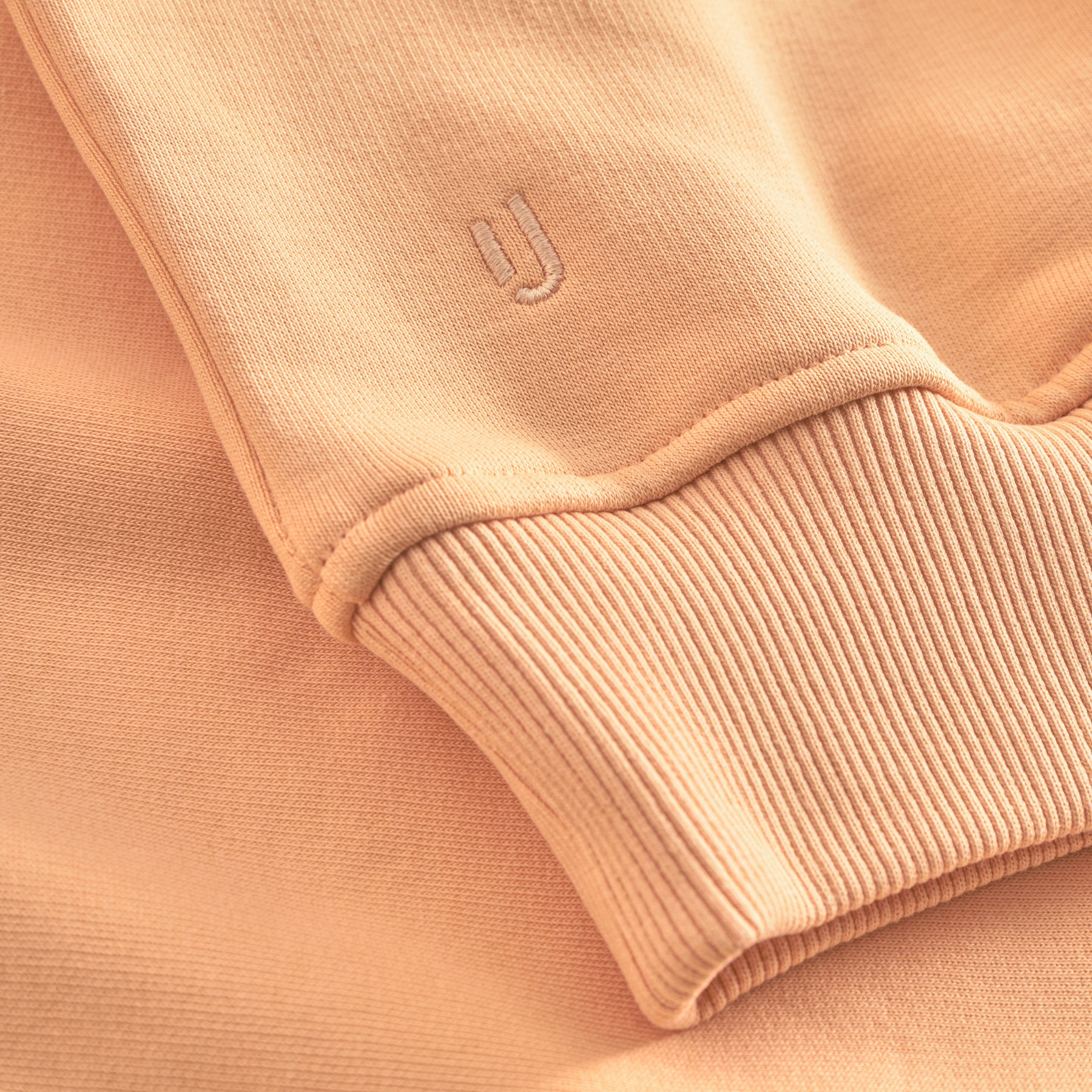 Ärmelabschluss eines peachfarbenen Oversized Hoodies "Cody" mit Johnny Urban Sticklogo